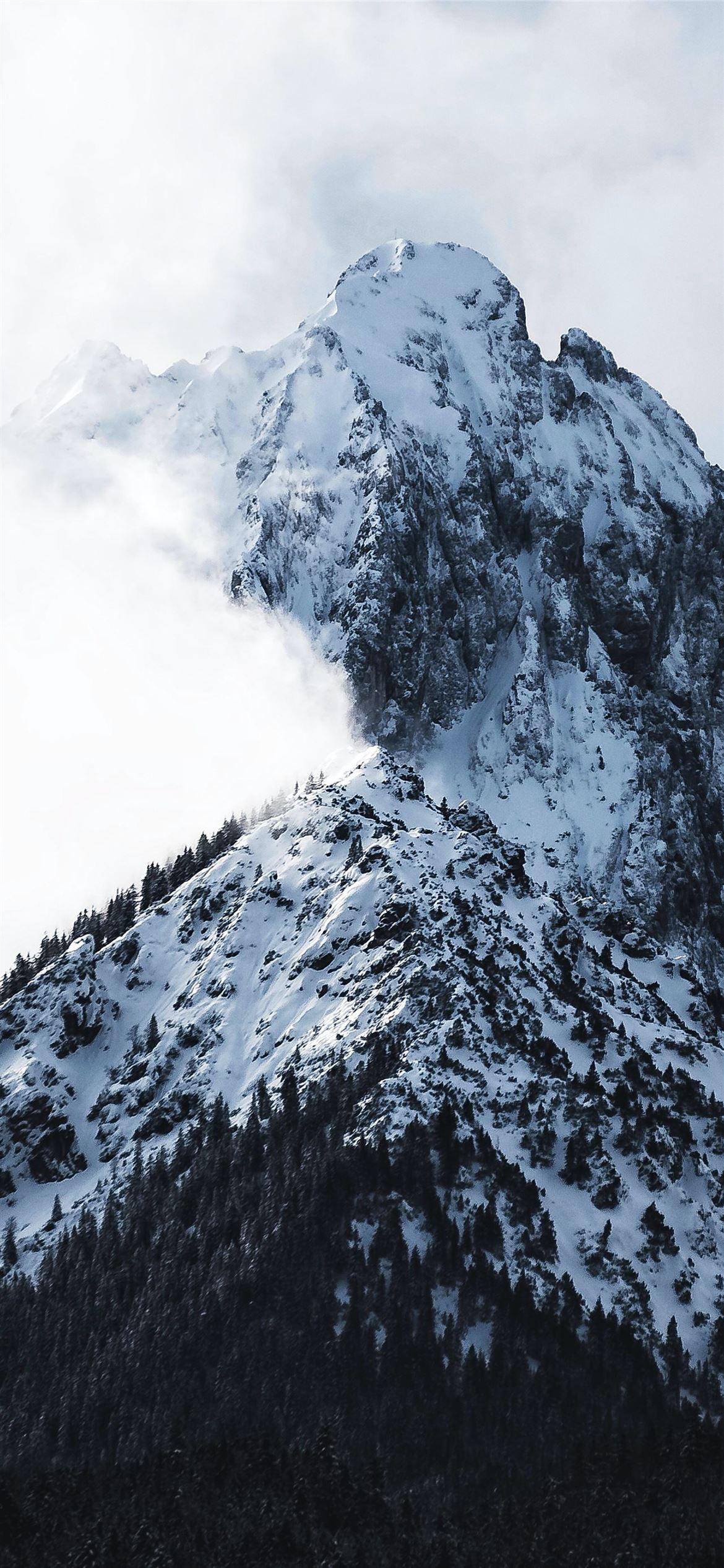 1170x2532 snowy mountain covered with clouds iPhone 12 Wallpaper Free Download