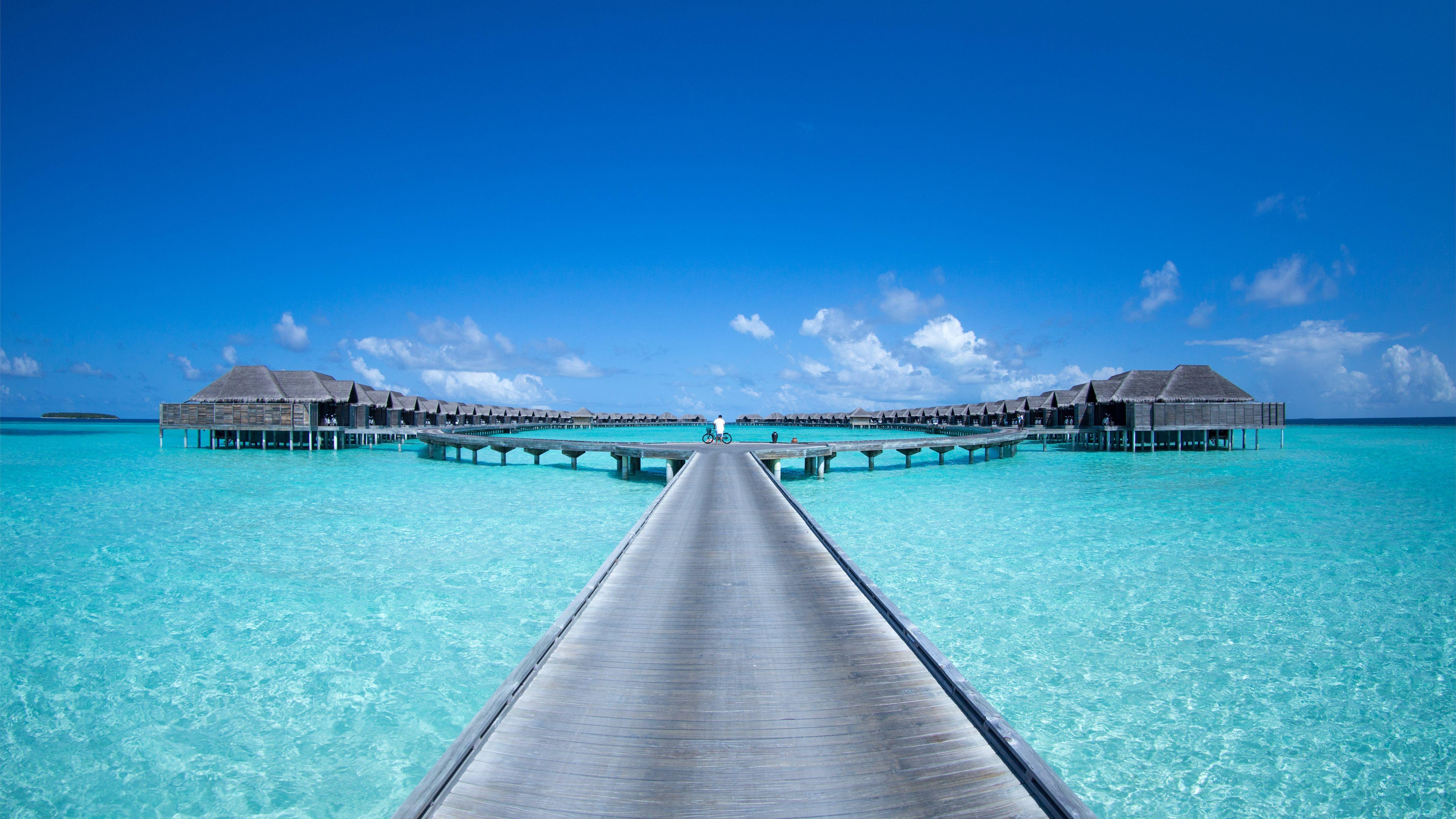 5120x2880 gray beach dock under blue skies MacBook Pro Wallpaper Download