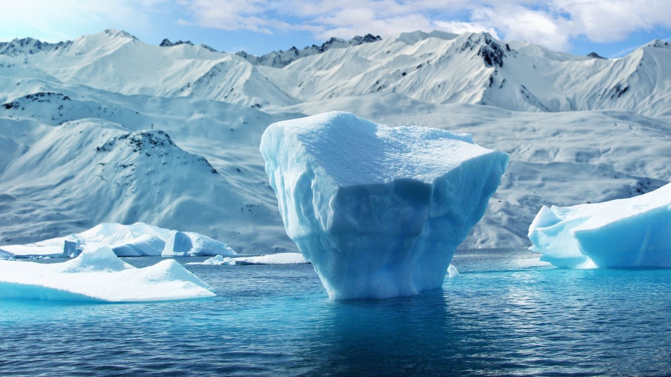 1366x768 Large Blocks Of Ice In The Water Against The Background Of Snow Capped Mountains Desktop Wallpaper 1366x768