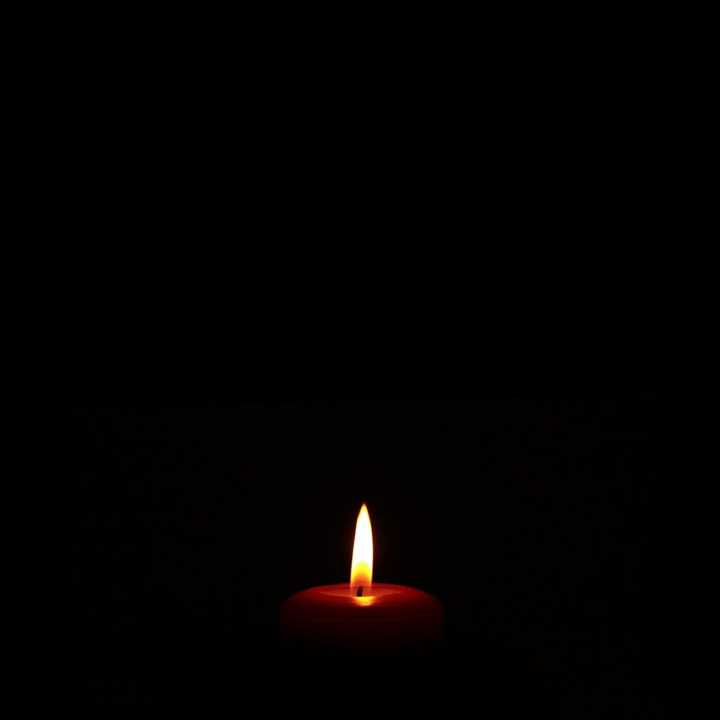 1024x1024 A lit candle in the dark on a black background. Candle