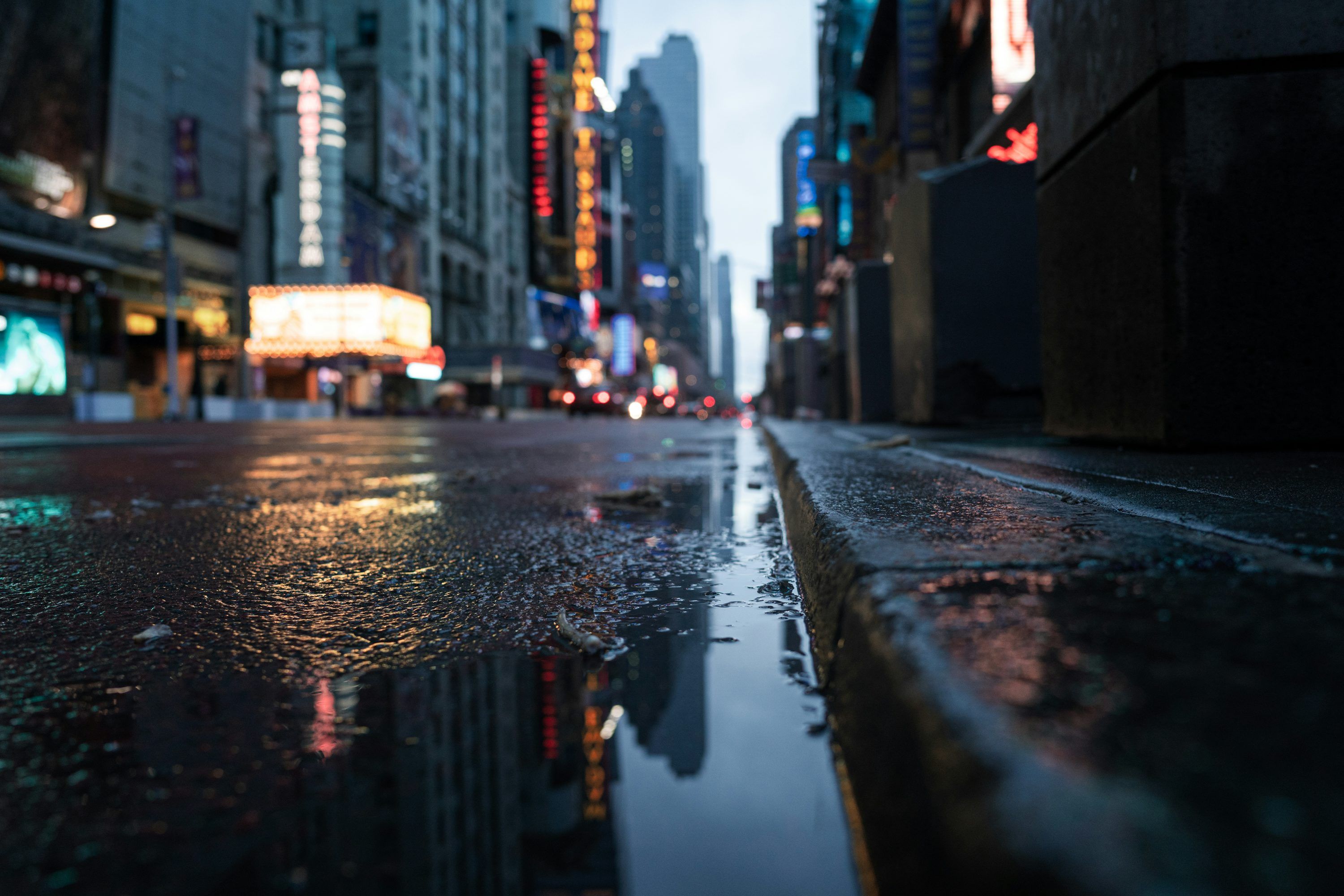 3000x2000 A wet city street with a puddle of water