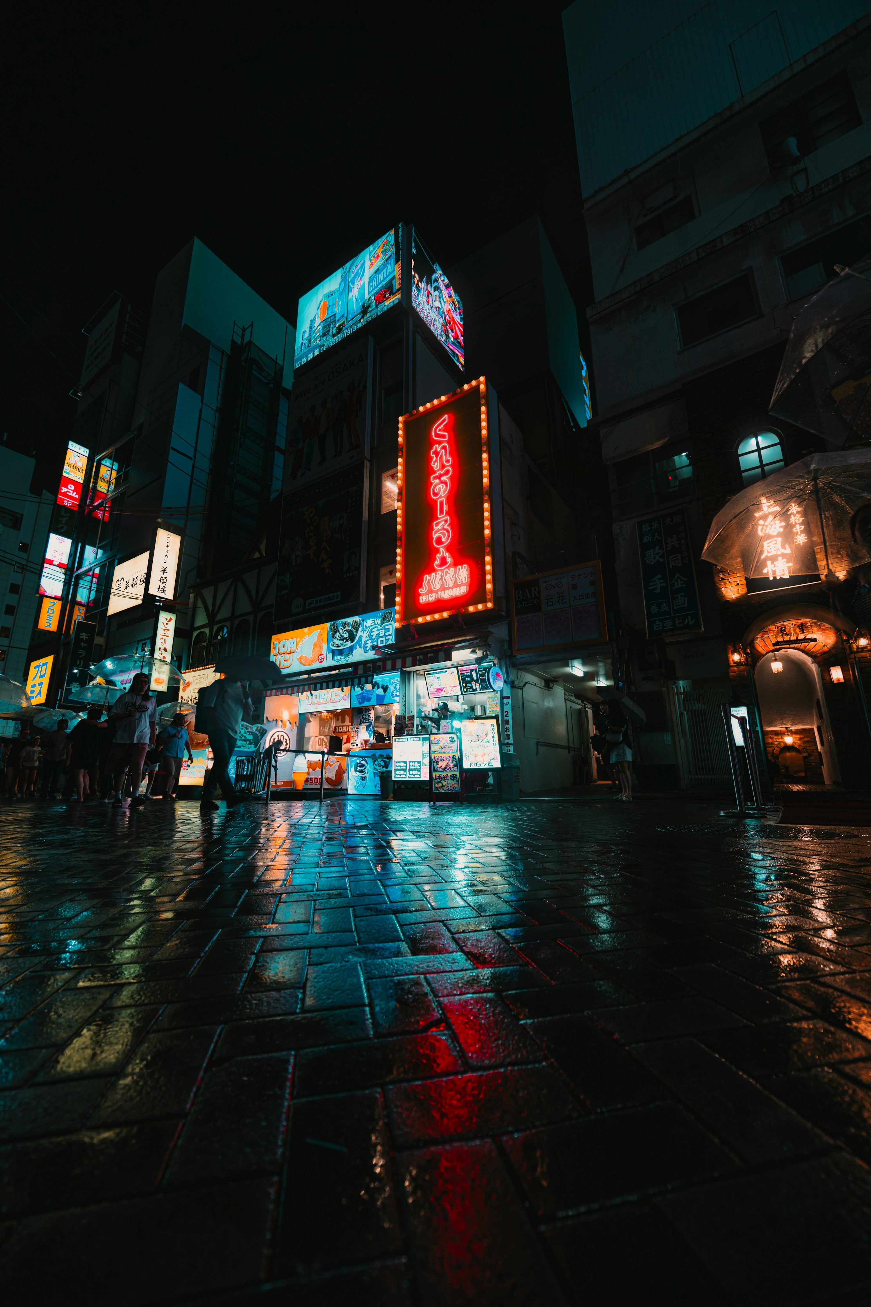 3000x4500 Neon signs illuminate wet city street at night
