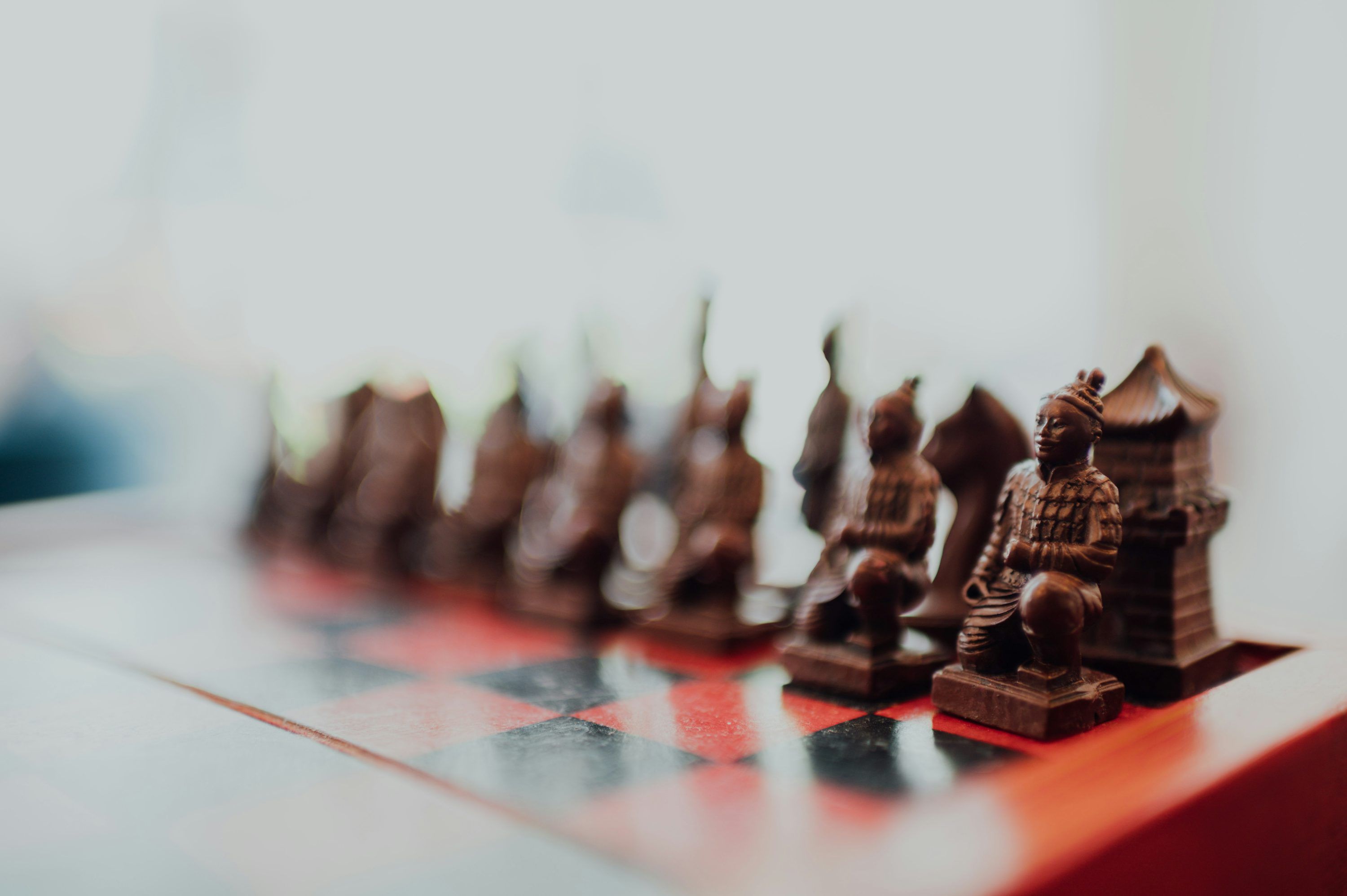 3000x1996 Brown and black chess pieces on red board