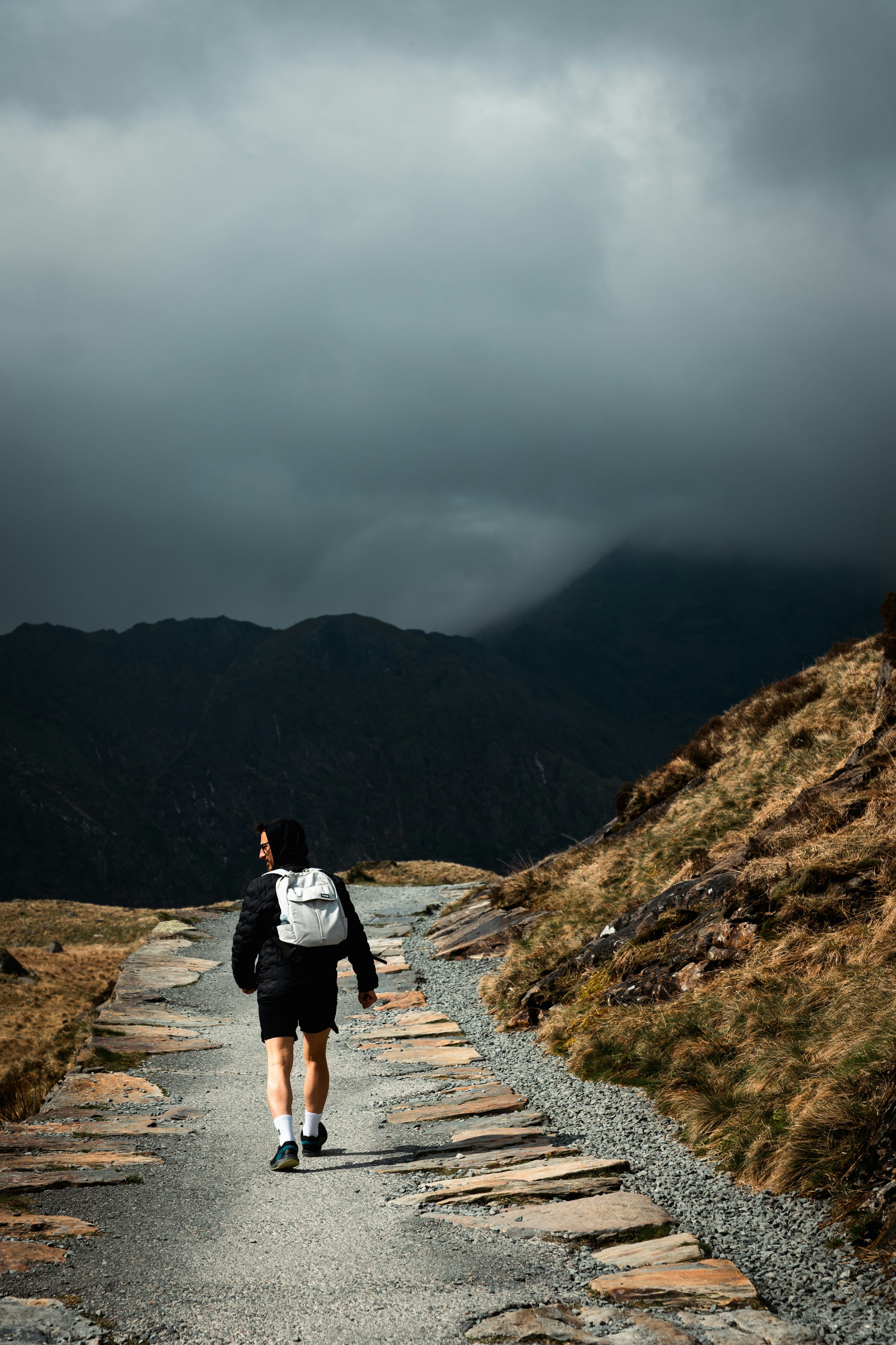 3000x4500 A person walks on a stone path up a mountain
