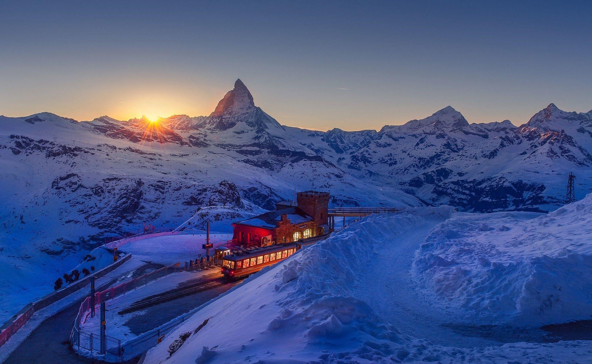 2000x1230 #mountains, #winter, #sunset, #landscape, #train station, #nature, # train, #Switzerland, #Matterhorn, #road, #snow, #lights, wallpaper