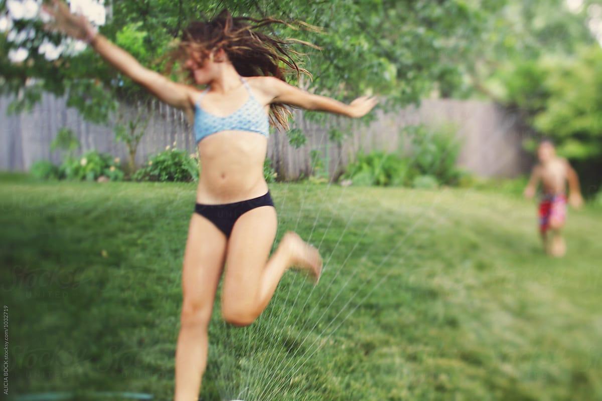 1200x800 A Teenage Girl Running Through A Sprinkler On A Hot Summer Day