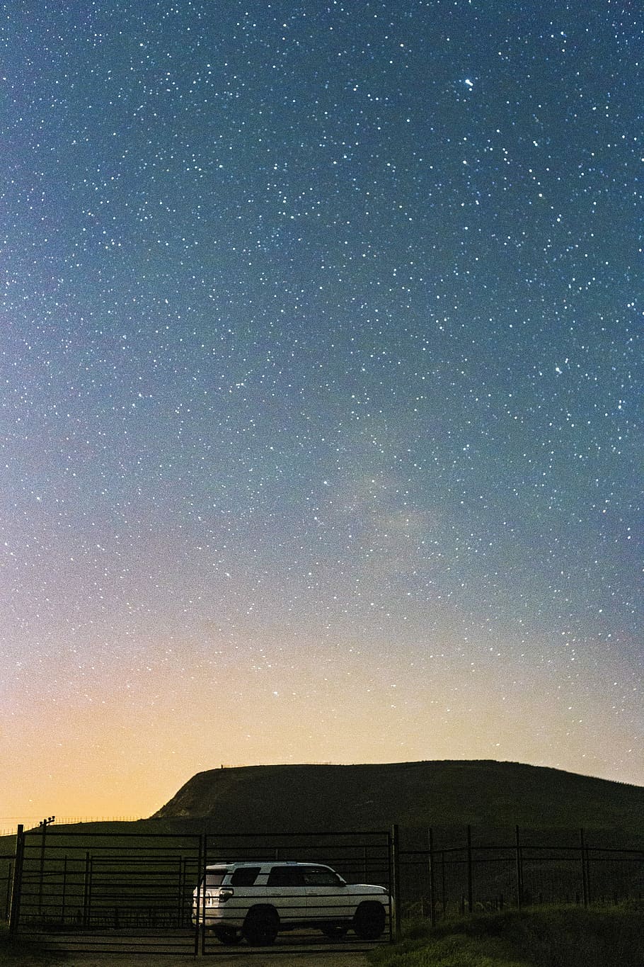 910x1365 HD wallpaper: white SUV under star field, white SUV parked near black gate