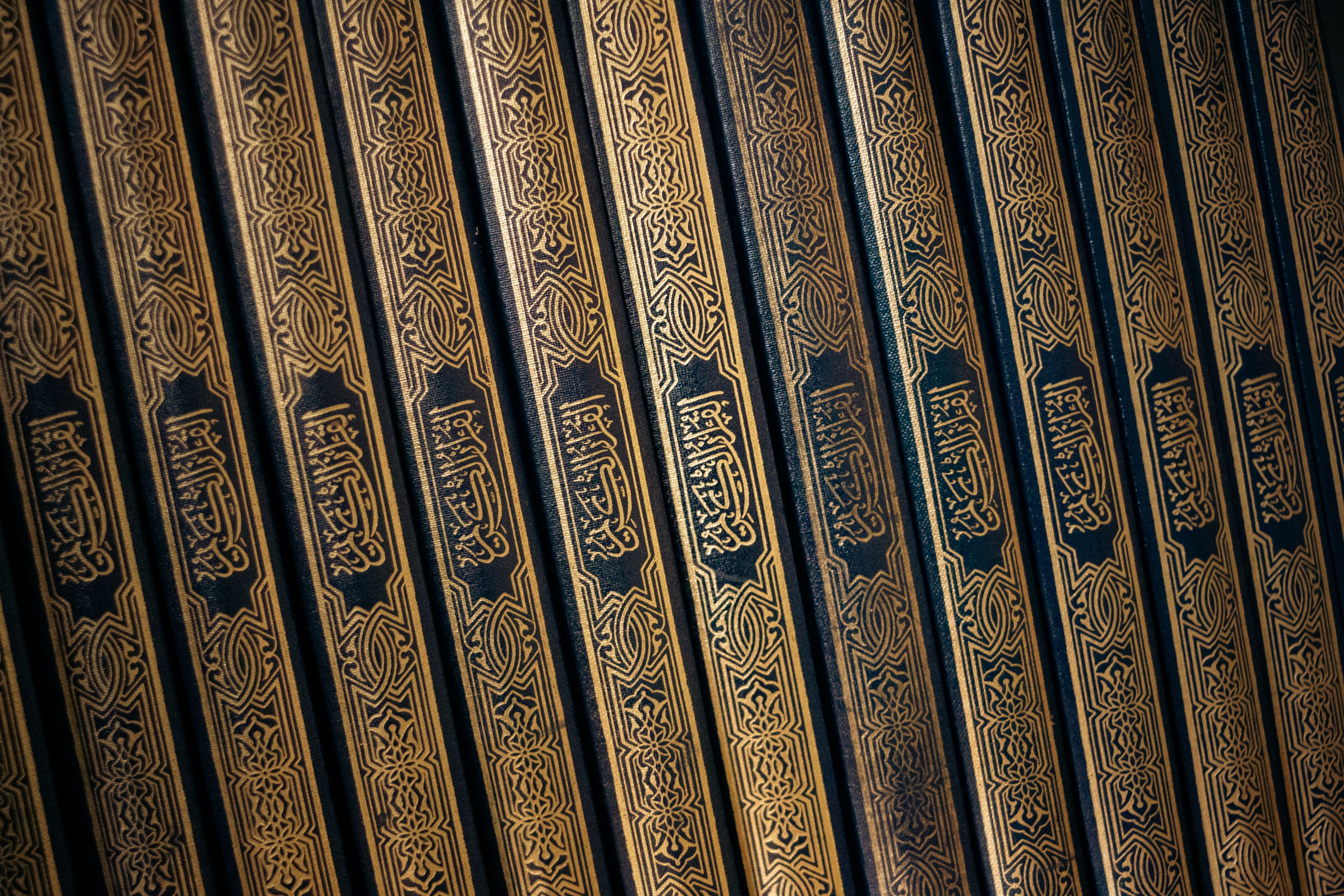 4687x3125 Elegant Row of Quranic Books with Arabic Calligraphy · Free