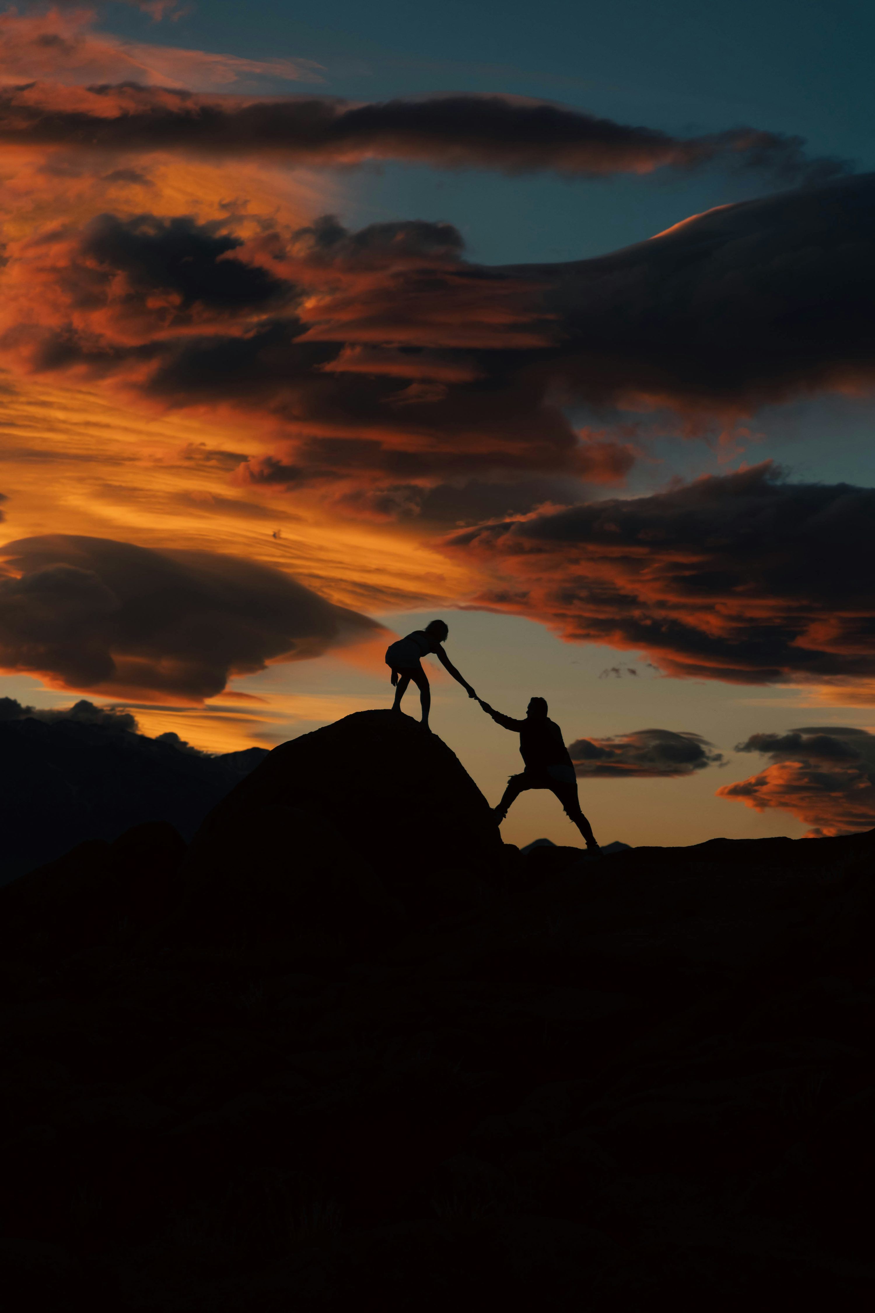 3000x4500 A couple of people holding hands on top of a hill