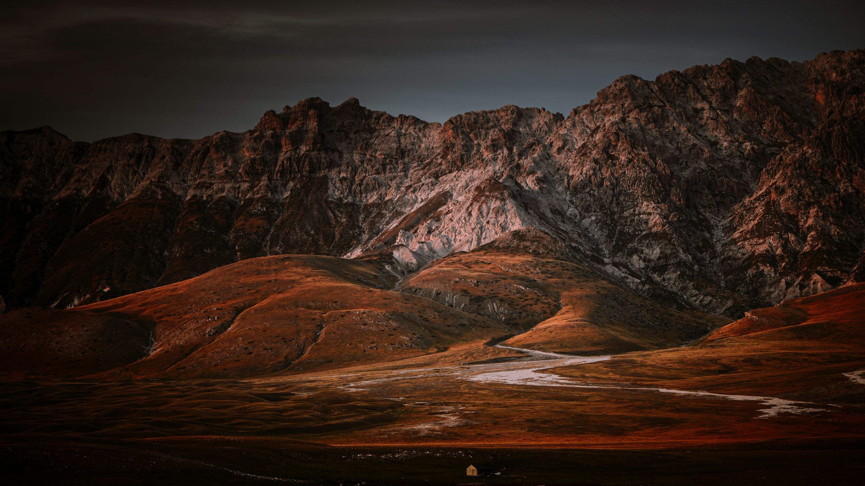 3000x1688 Mountains and rolling hills under a moody sky