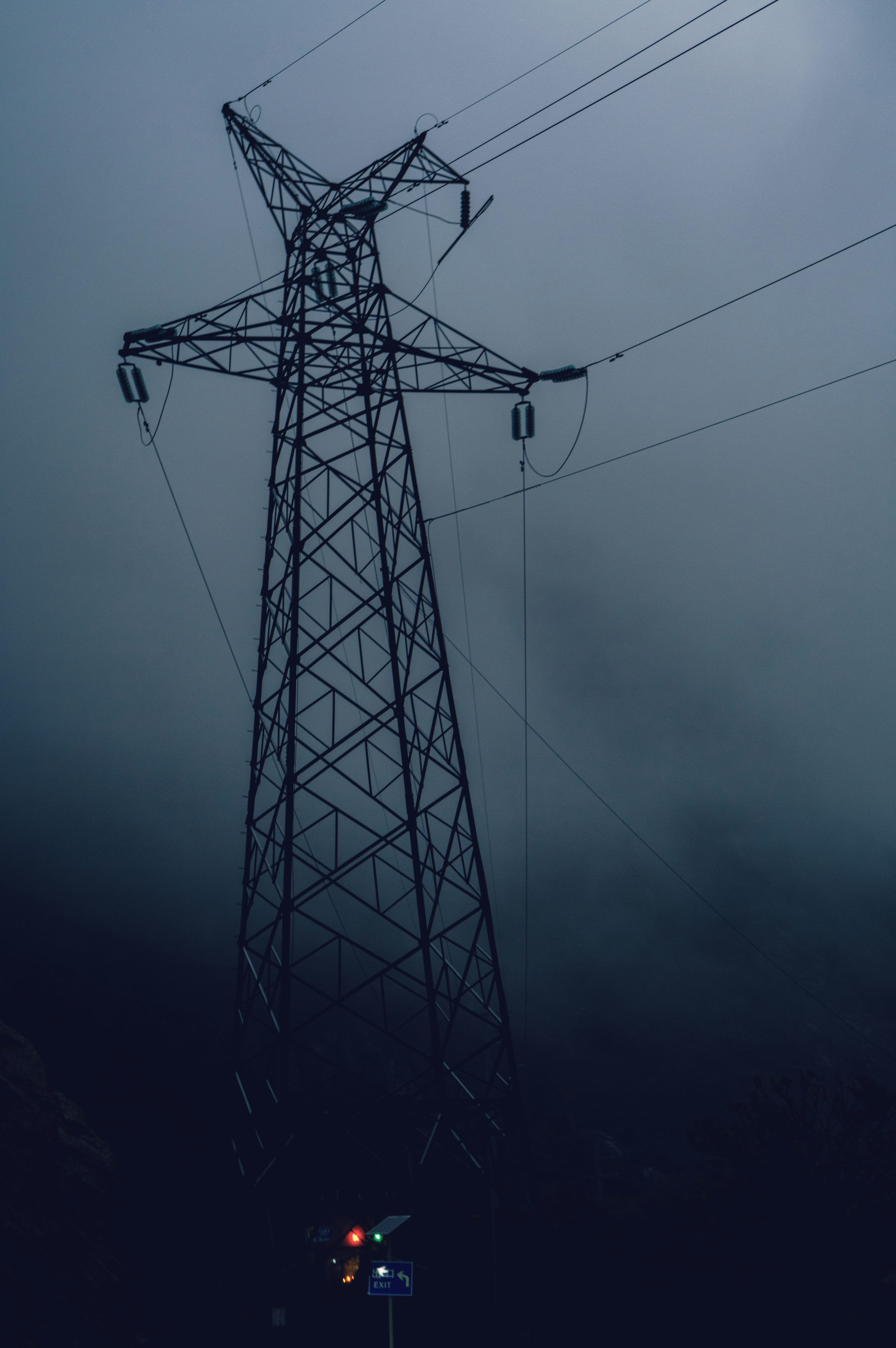 3000x4513 A tall electricity pylon in the fog