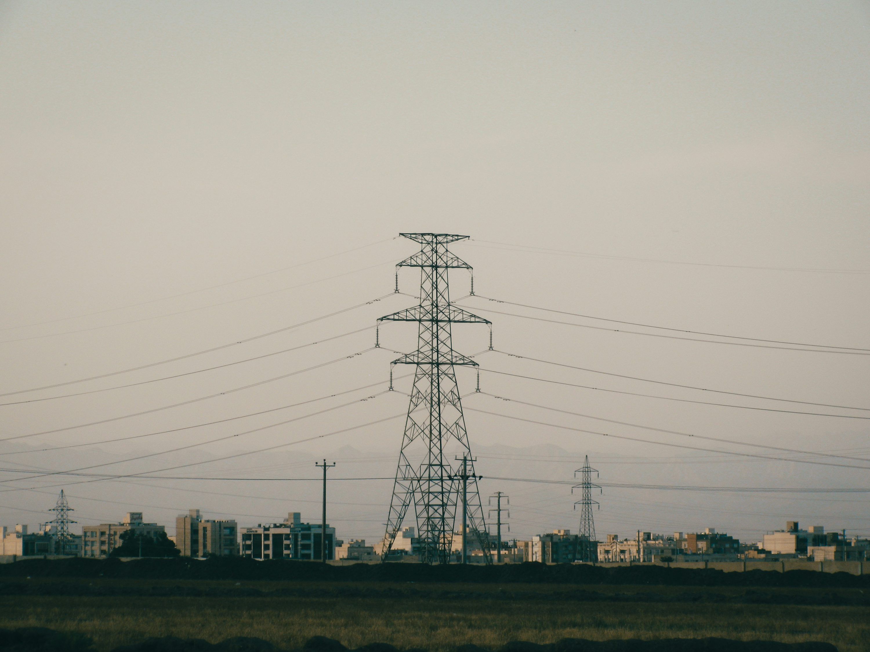 3000x2250 Electricity pylon and power lines over a distant cityscape