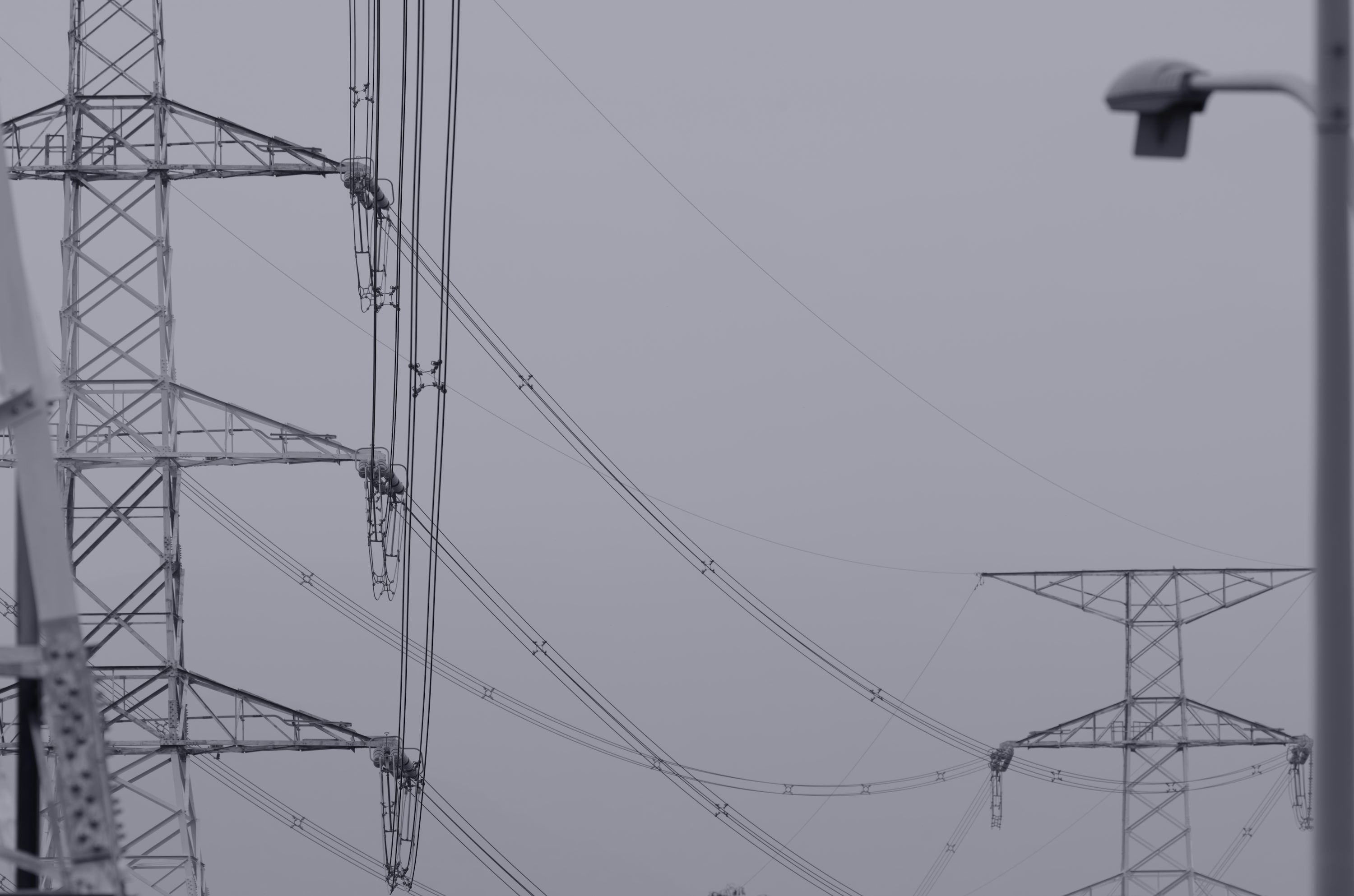 3000x1986 Multiple electricity pylons and power lines against a grey sky