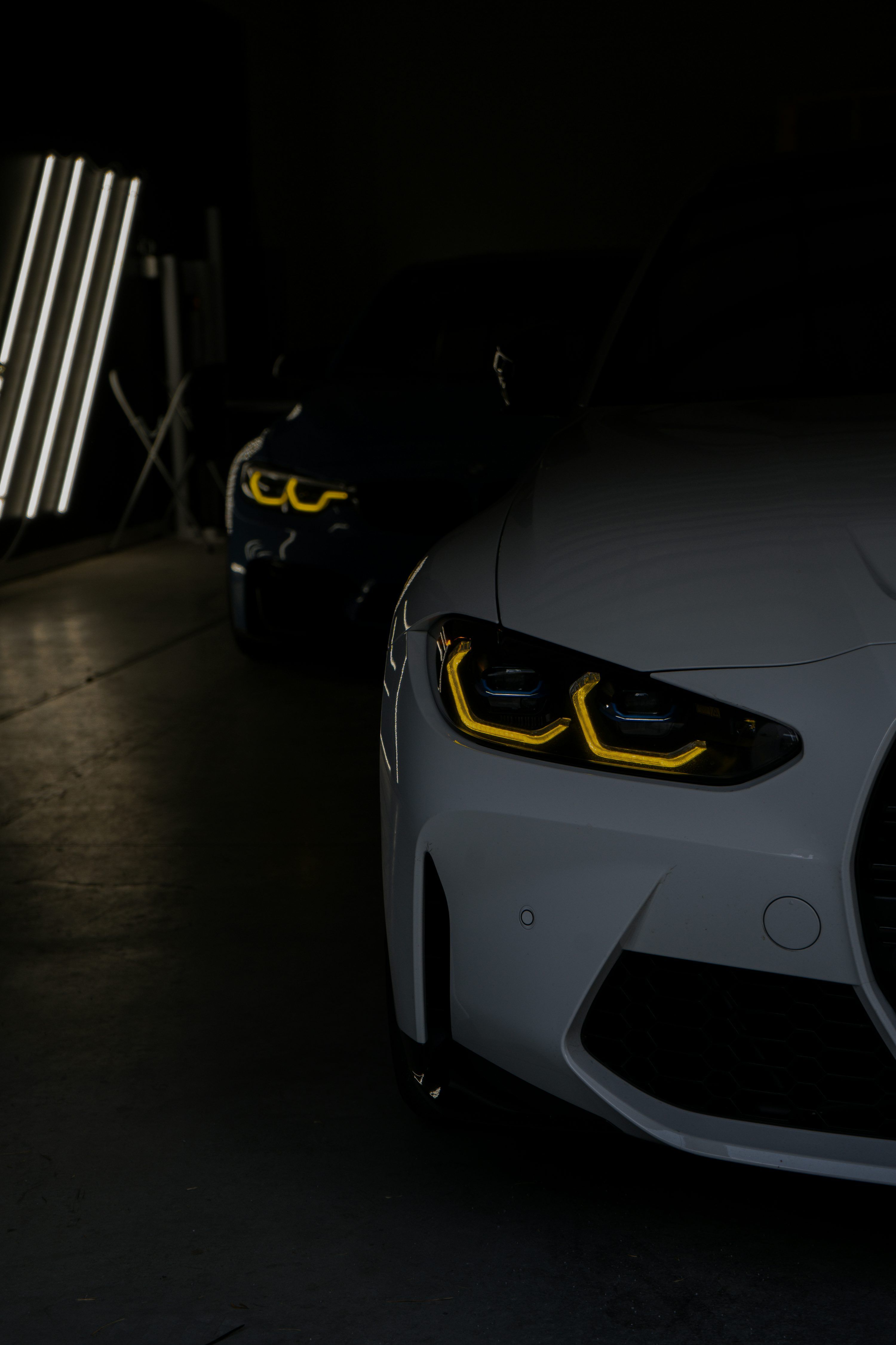 3000x4500 White BMW with illuminated headlights