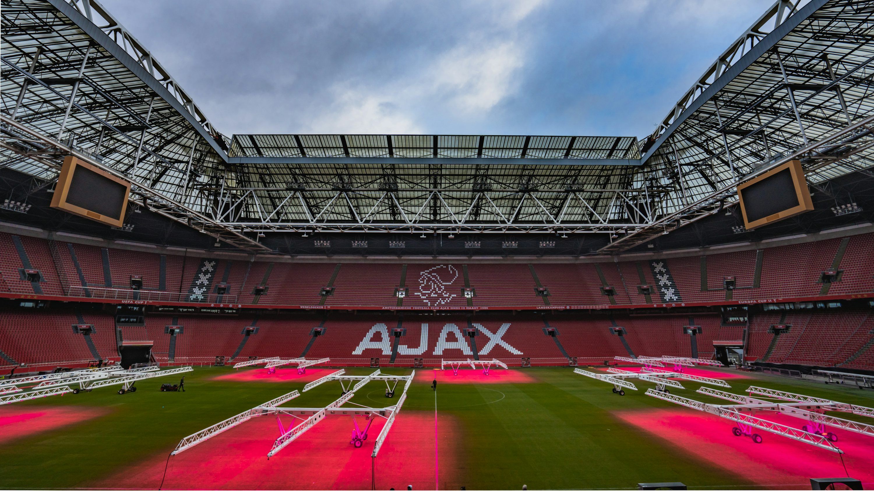 3000x1688 The inside of a stadium with a red field
