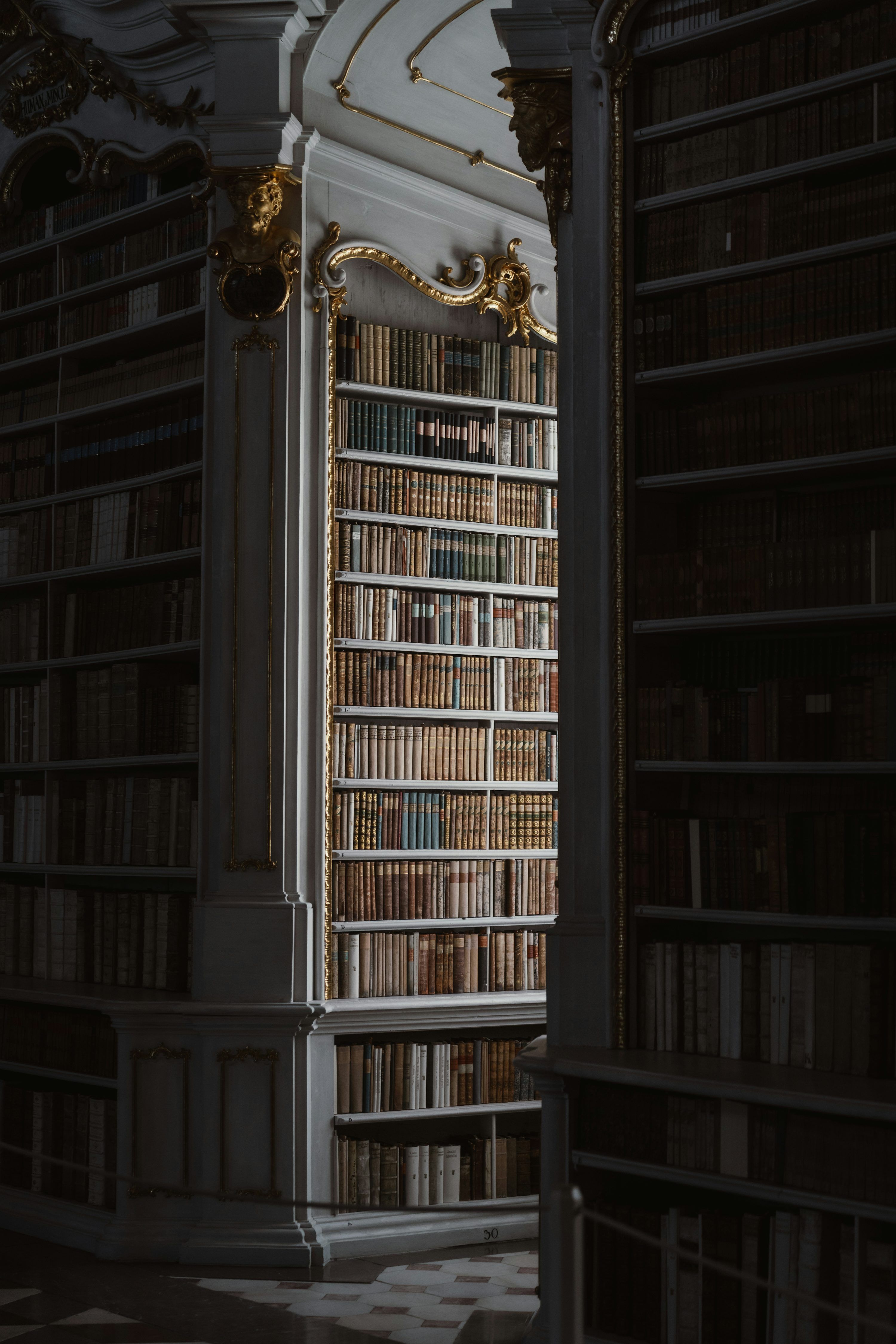 3000x4498 Tall bookshelves filled with old books in a library