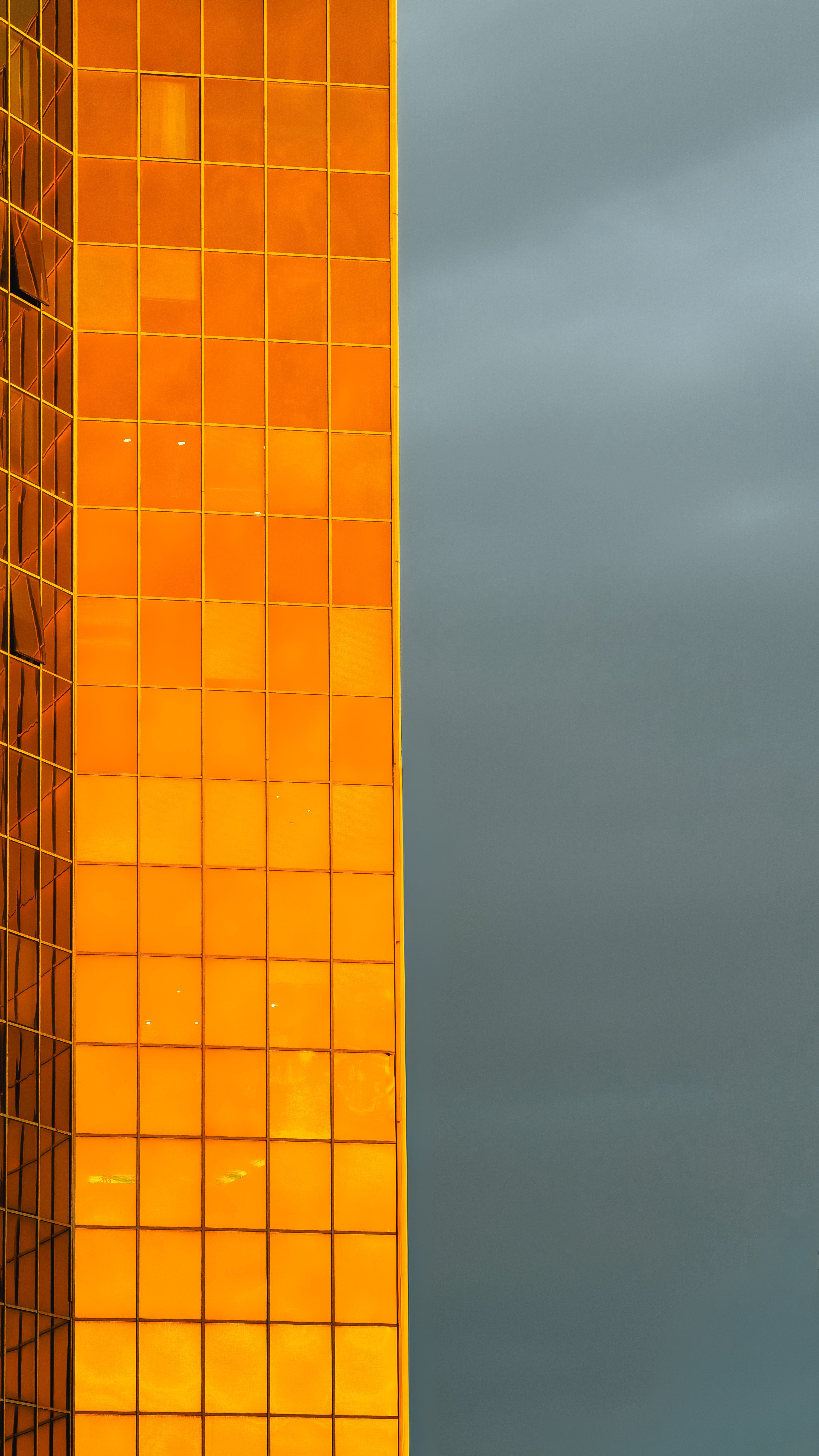 4303x7650 Golden Glass Facade Against Dramatic Sky · Free