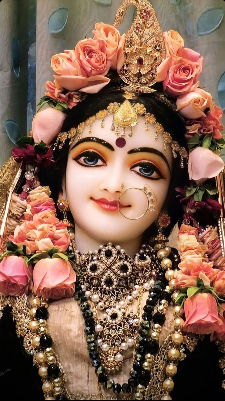 736x1312 Radhe! A statue with flowers around it and a face painted in white, pink and gold. Radha rani wallpaper full hd, Radha beauty, Vrindavan photography picture