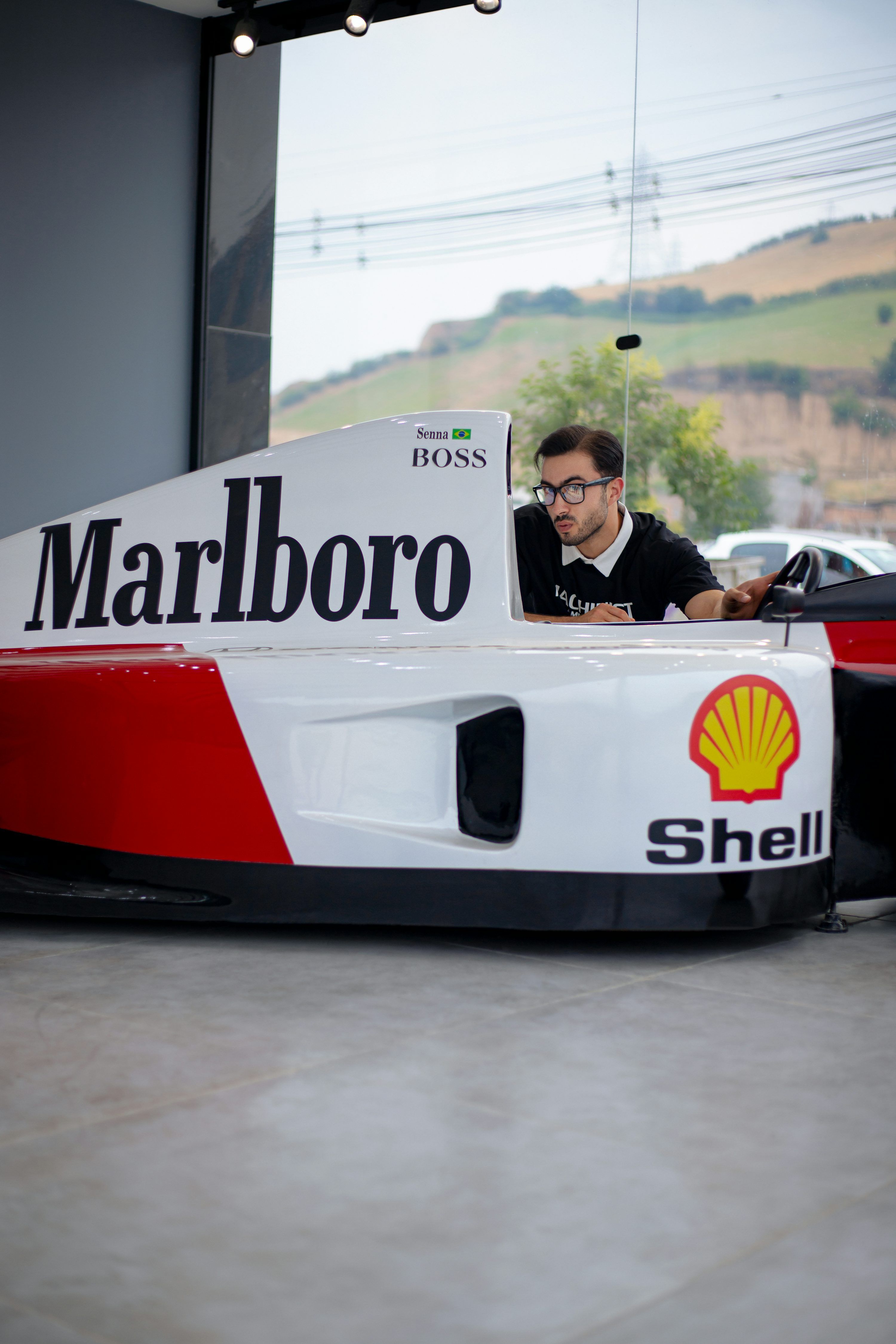 3000x4500 A man sitting in a racing car in a garage