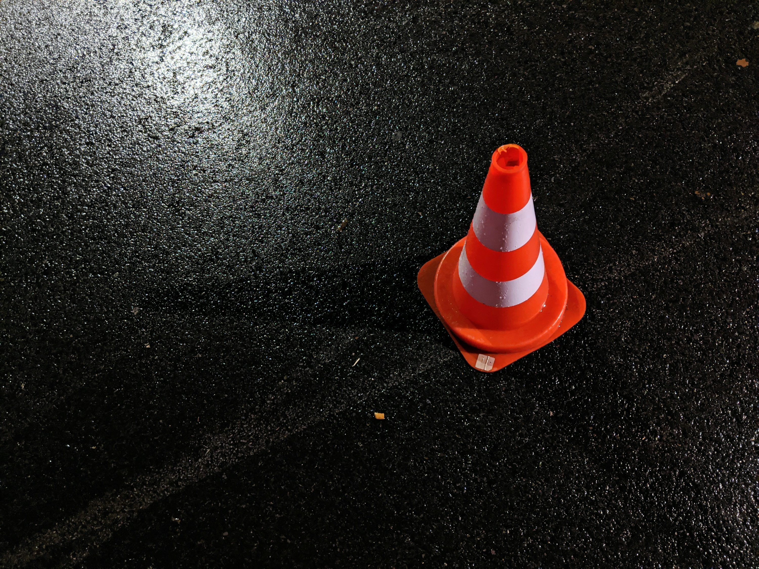 3000x2250 Orange and white striped traffic cone on water