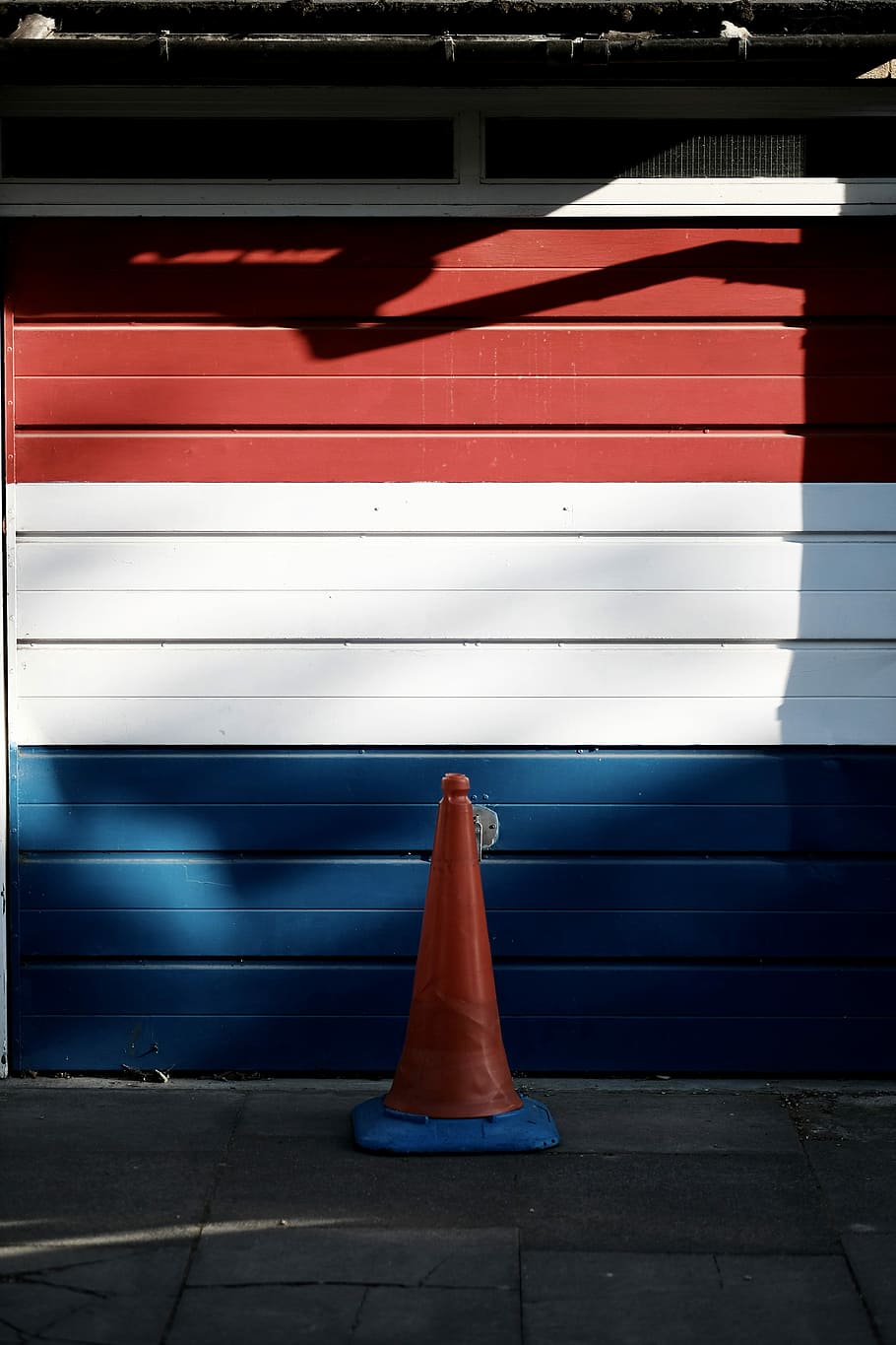 910x1365 HD wallpaper: red, white, and blue wooden garage door, red and blue traffic cone
