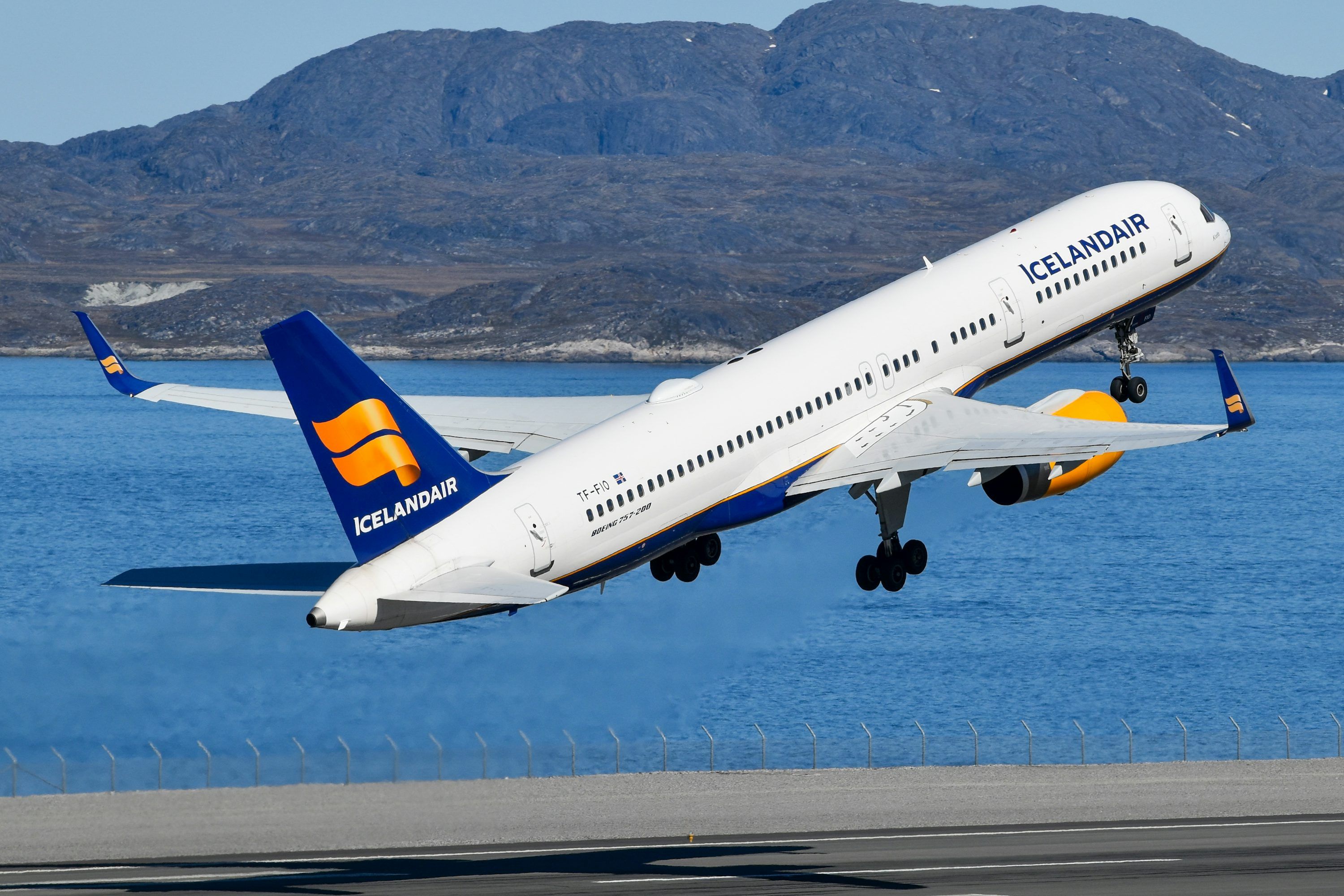 3000x2000 White icelandair airplane taking off above blue water and mountains