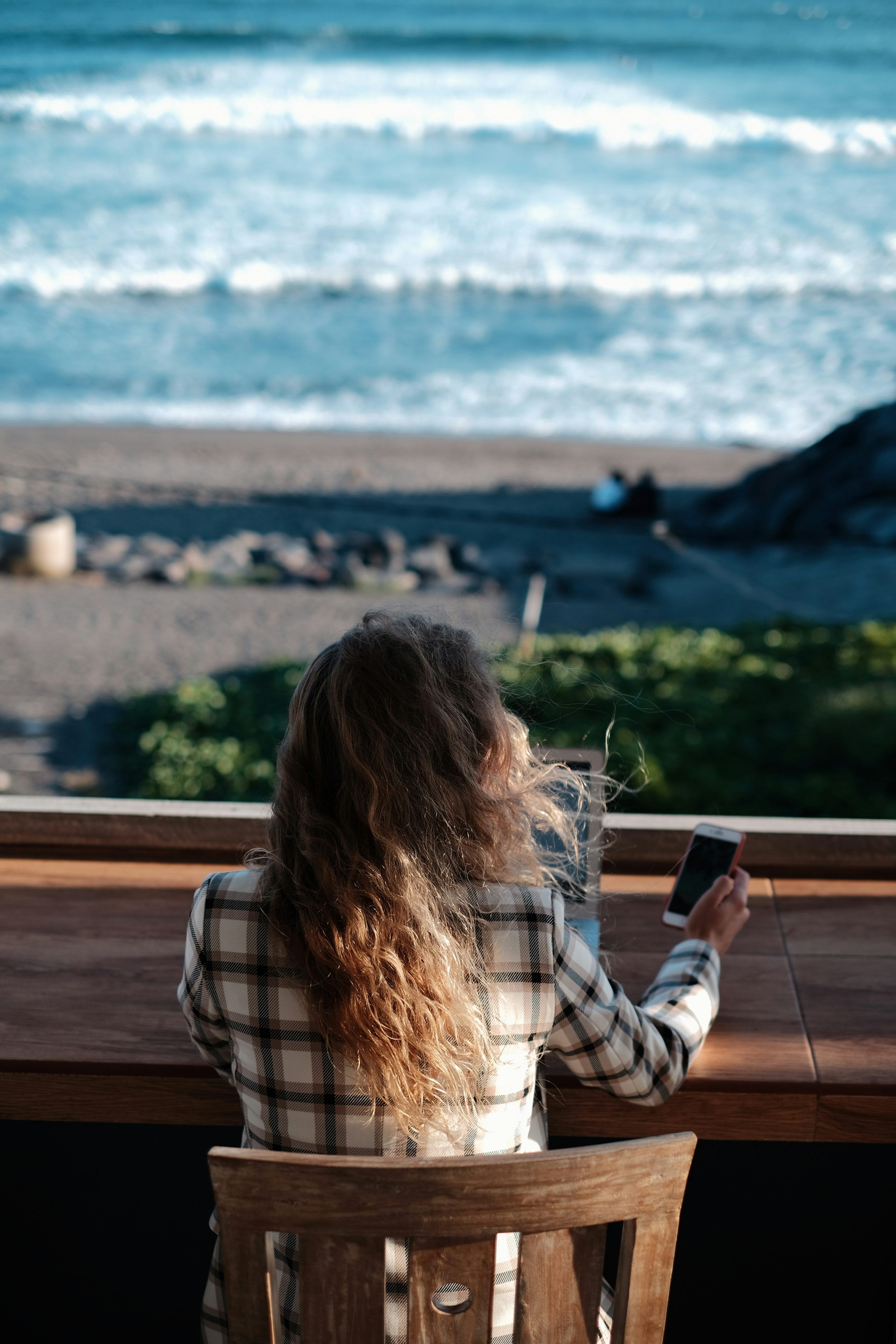 3000x4500 Woman in white and black plaid shirt holding black smartphone