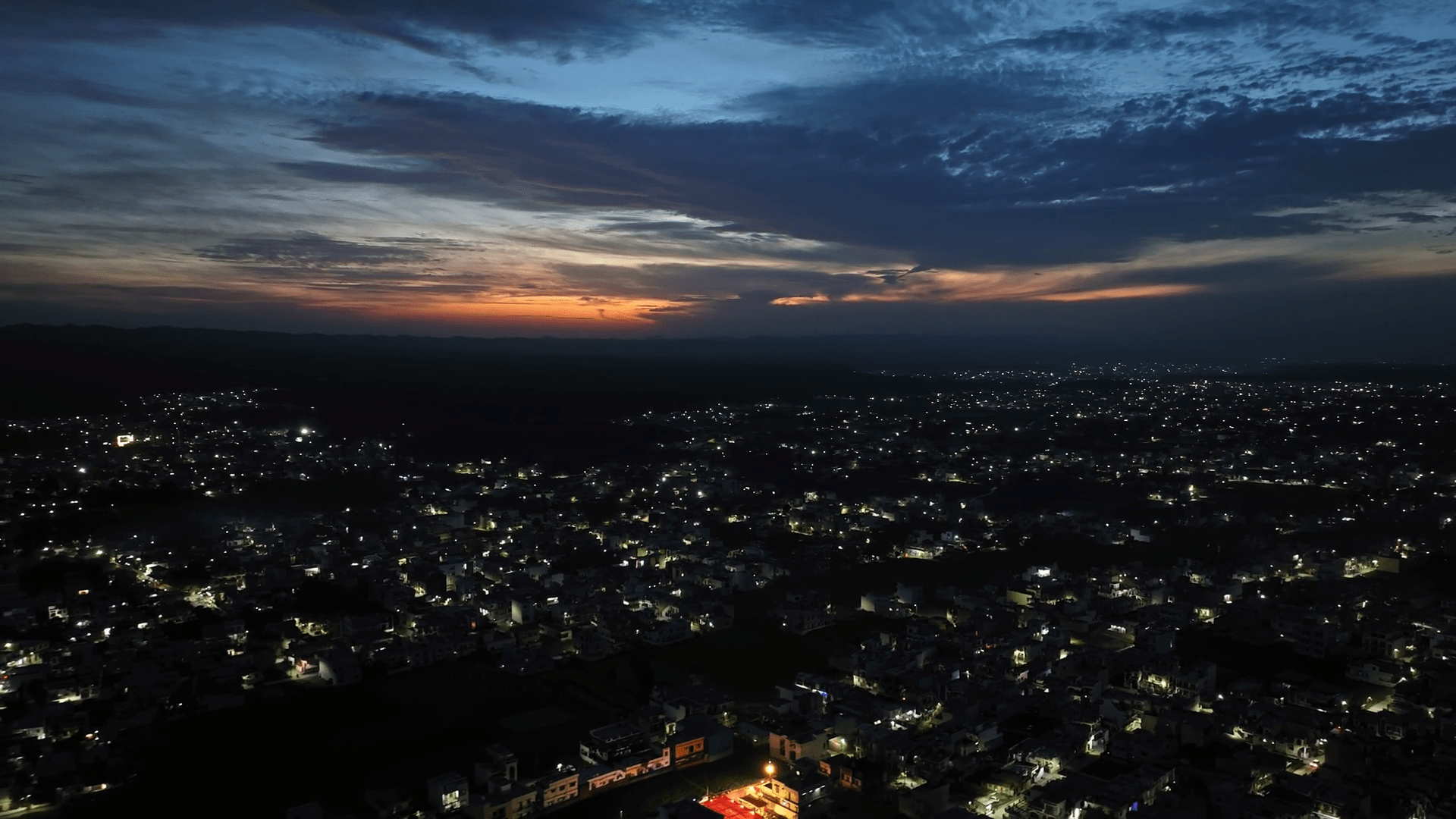 1920x1080 Aerial view of Dehradun, a smart Indian city during a beautiful orange sunset with rows of residential houses in Dehradun, Uttarakhand, India. A beautiful city in India at night