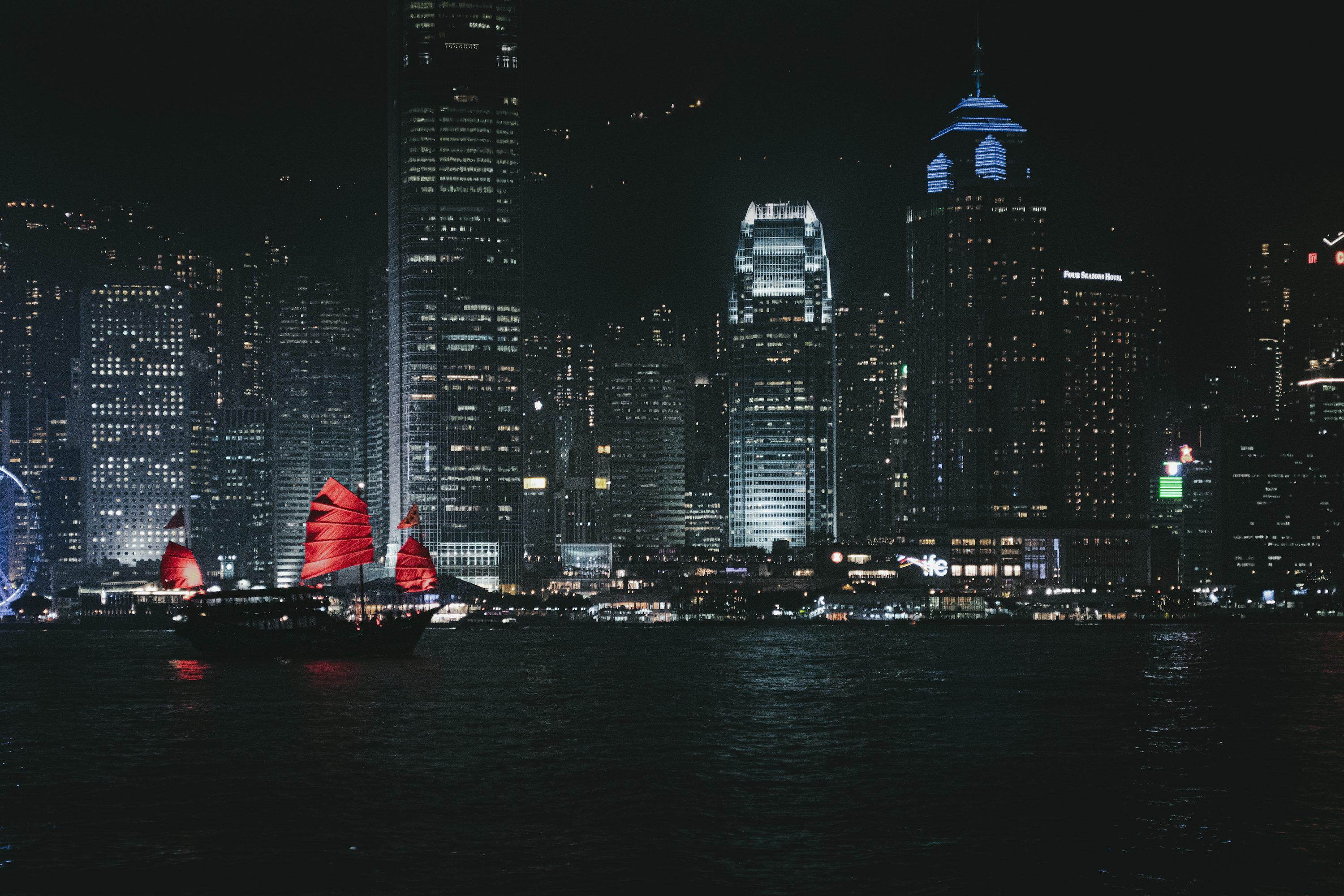 3000x2000 Red Sailed Junks Float On Dark Water Near City Lights