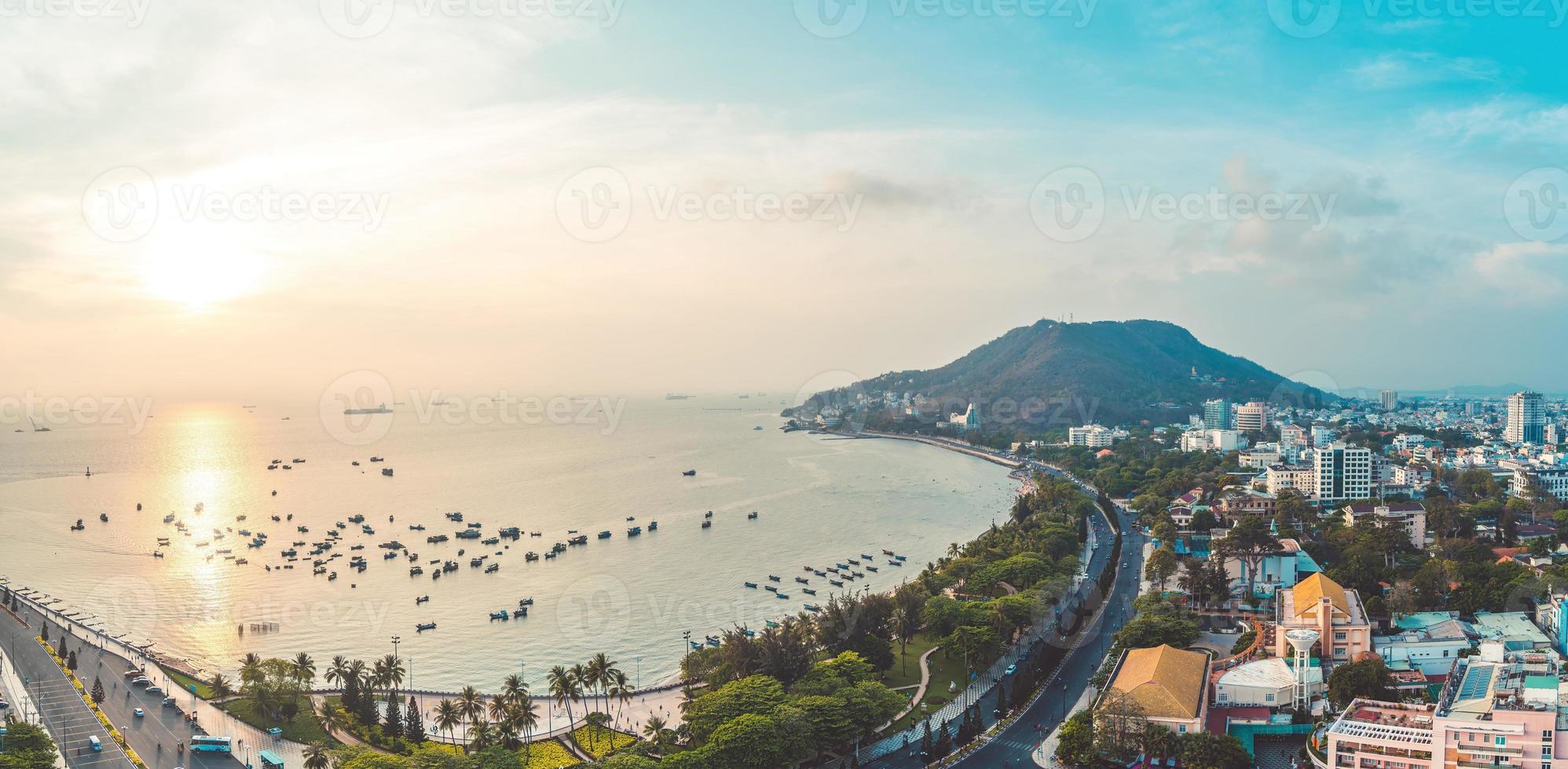 1996x980 Vung Tau city aerial view with beautiful sunset and so many boats. Panoramic coastal Vung Tau view from above, with waves, coastline, streets, coconut trees and Tao Phung mountain in Vietnam. 10039276
