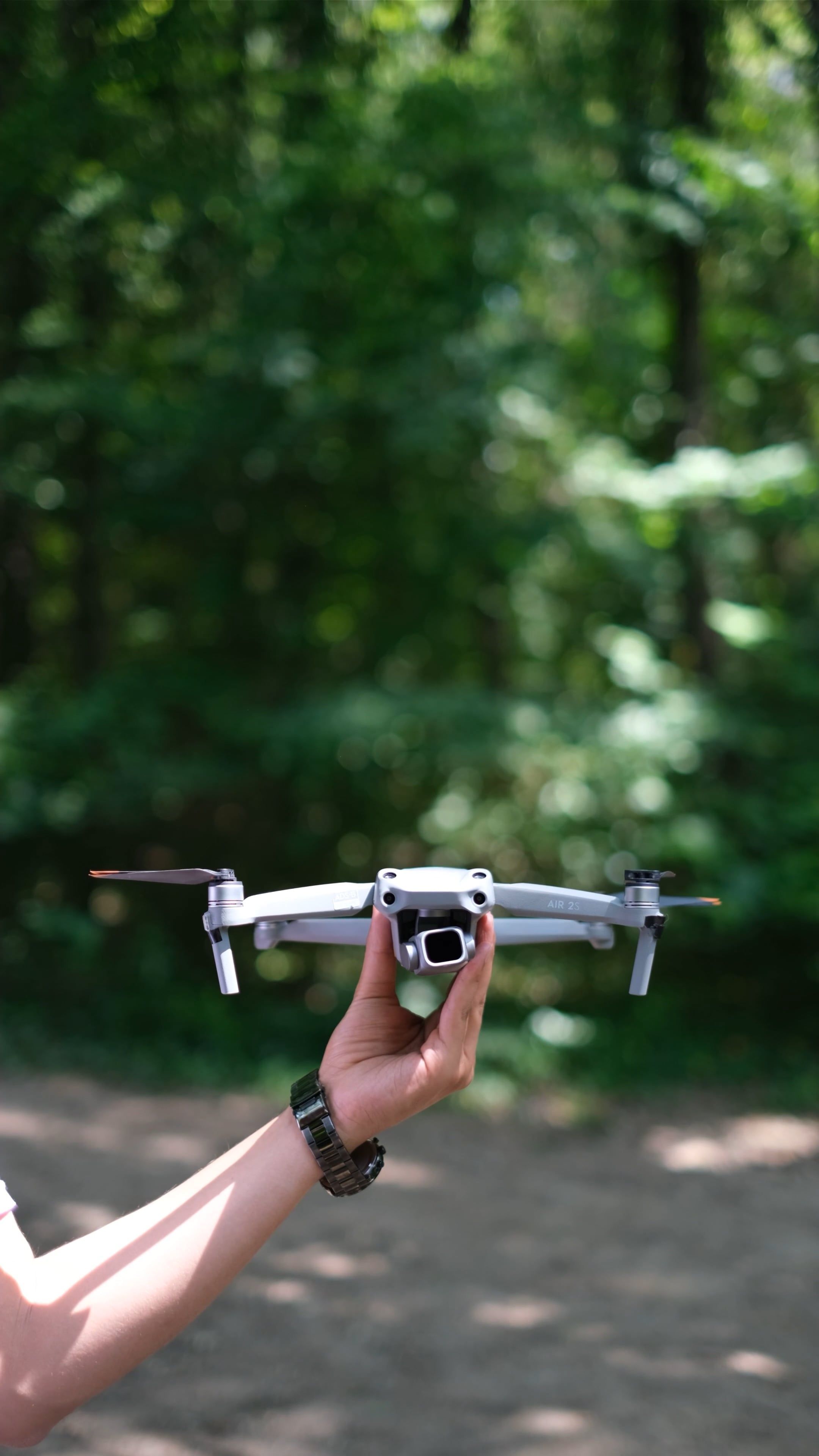 2160x3840 A man holding a small drone in his hand