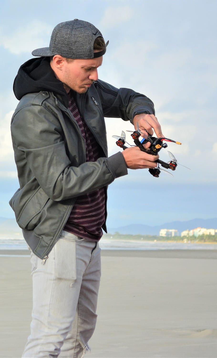 910x1499 HD wallpaper: man, drone, the pilot of the drone, jacket, cap, jeans, beach