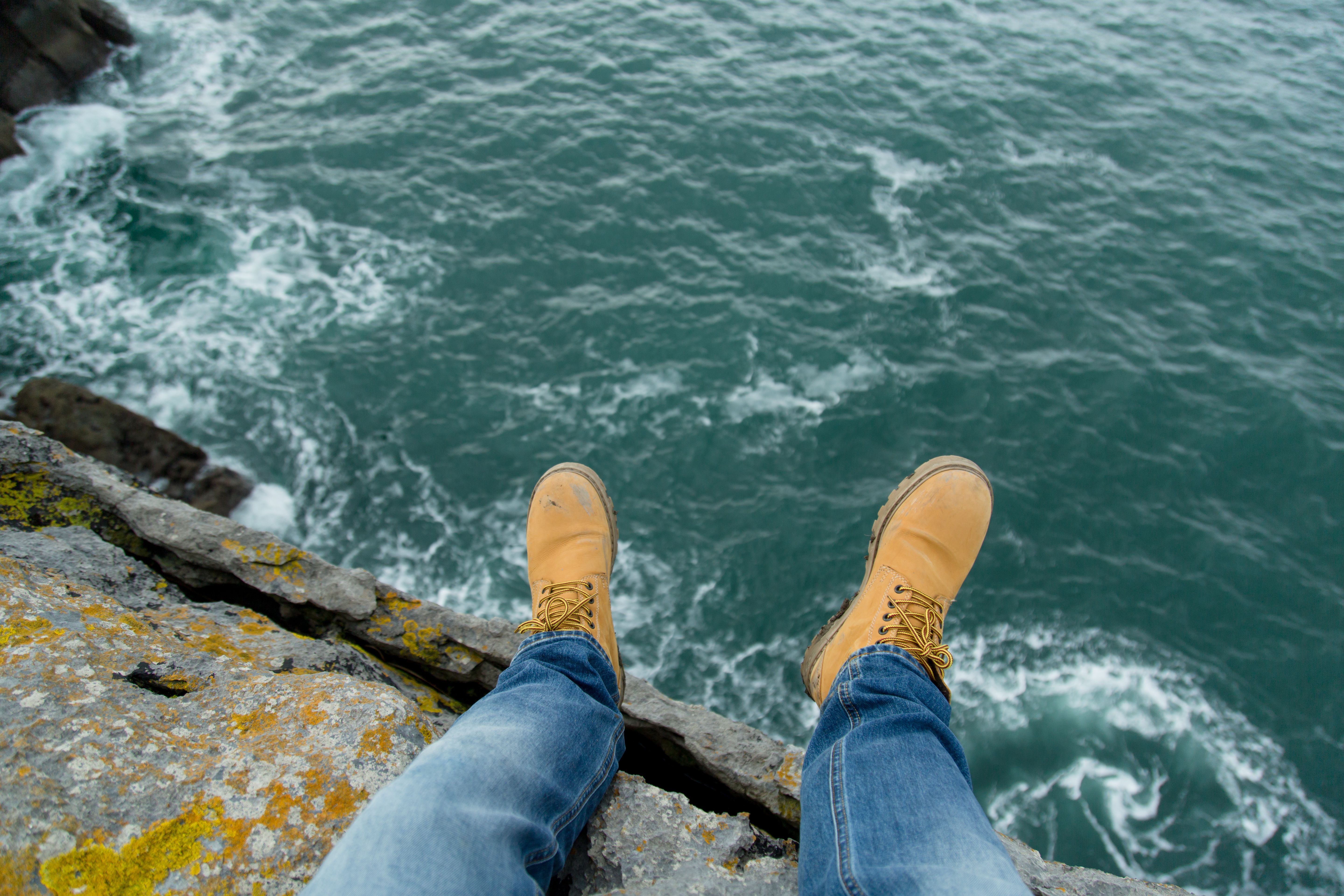 5760x3840 Person Wearing Pair of Brown Suede Work Boots Facing Body of Water · Free