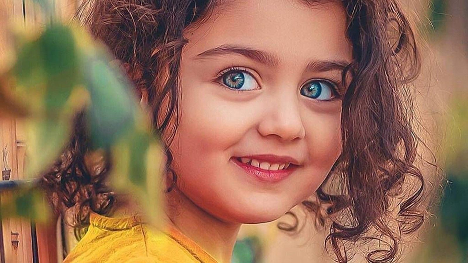 1600x900 Smiley Curly Hair Blue Eyes Cute Girl In Blur Background Wearing Yellow Dress HD Cute Wallpaper