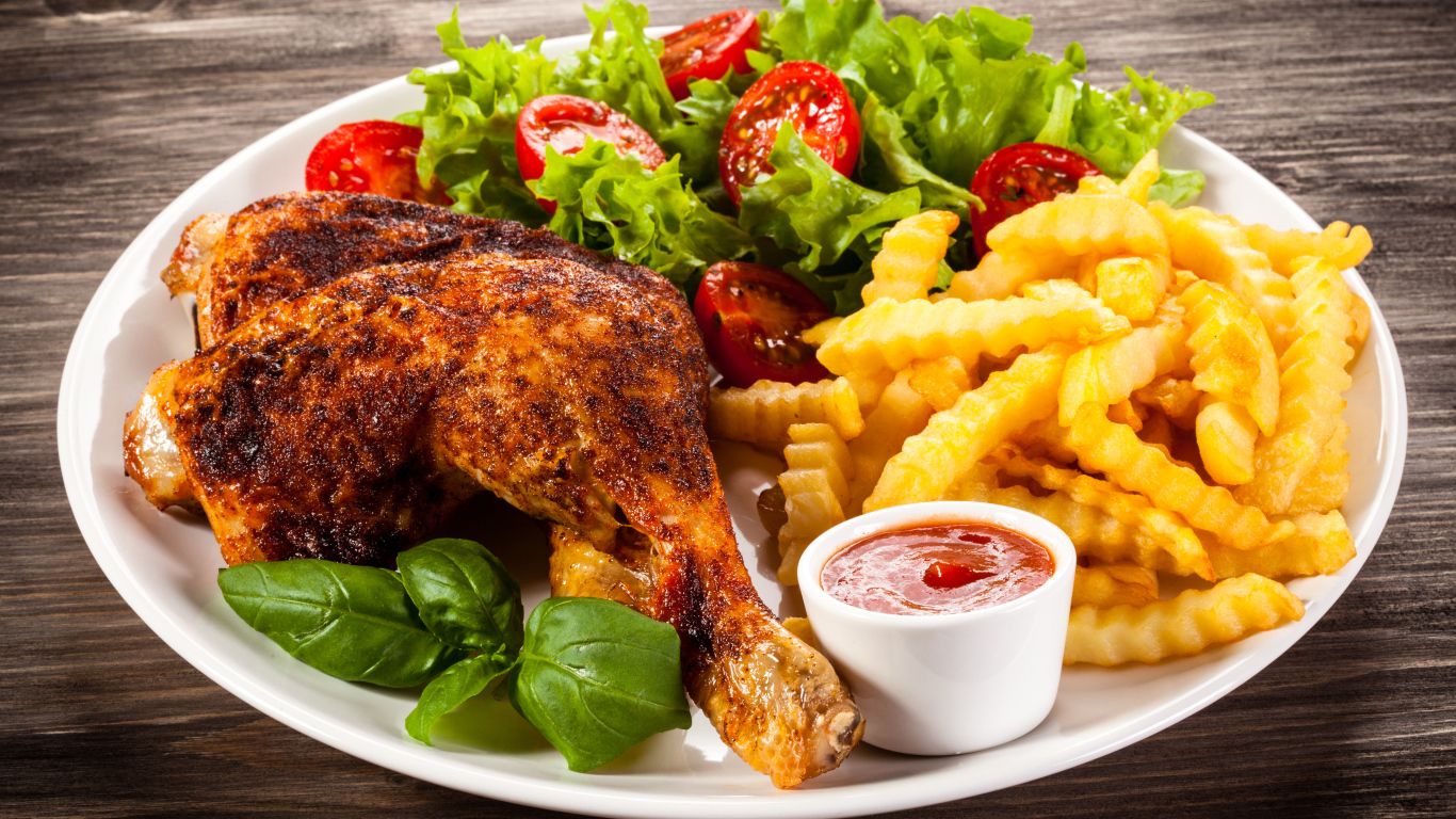 1366x768 Ruddy chicken leg with vegetables on a plate Desktop wallpaper 1366x768