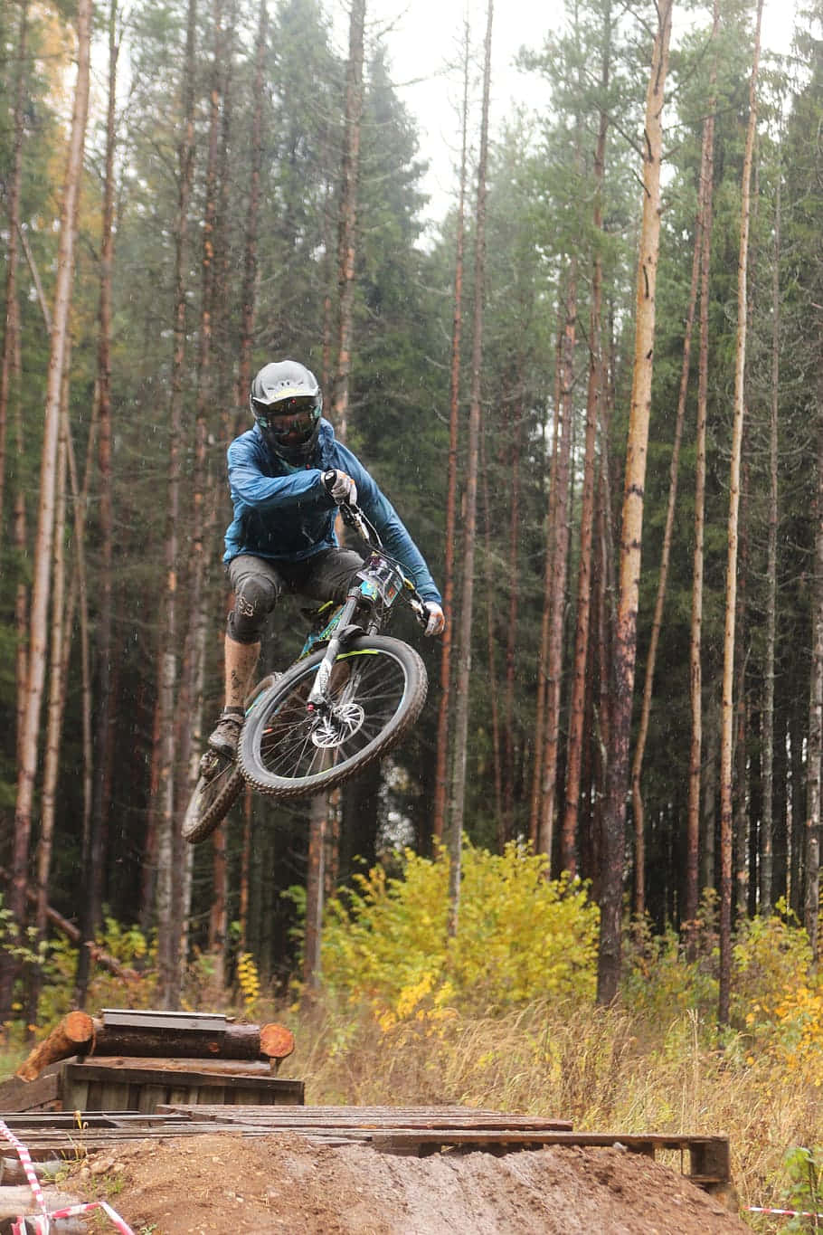 910x1365 Download Mountain Biker Aerial Jump Forest Wallpaper