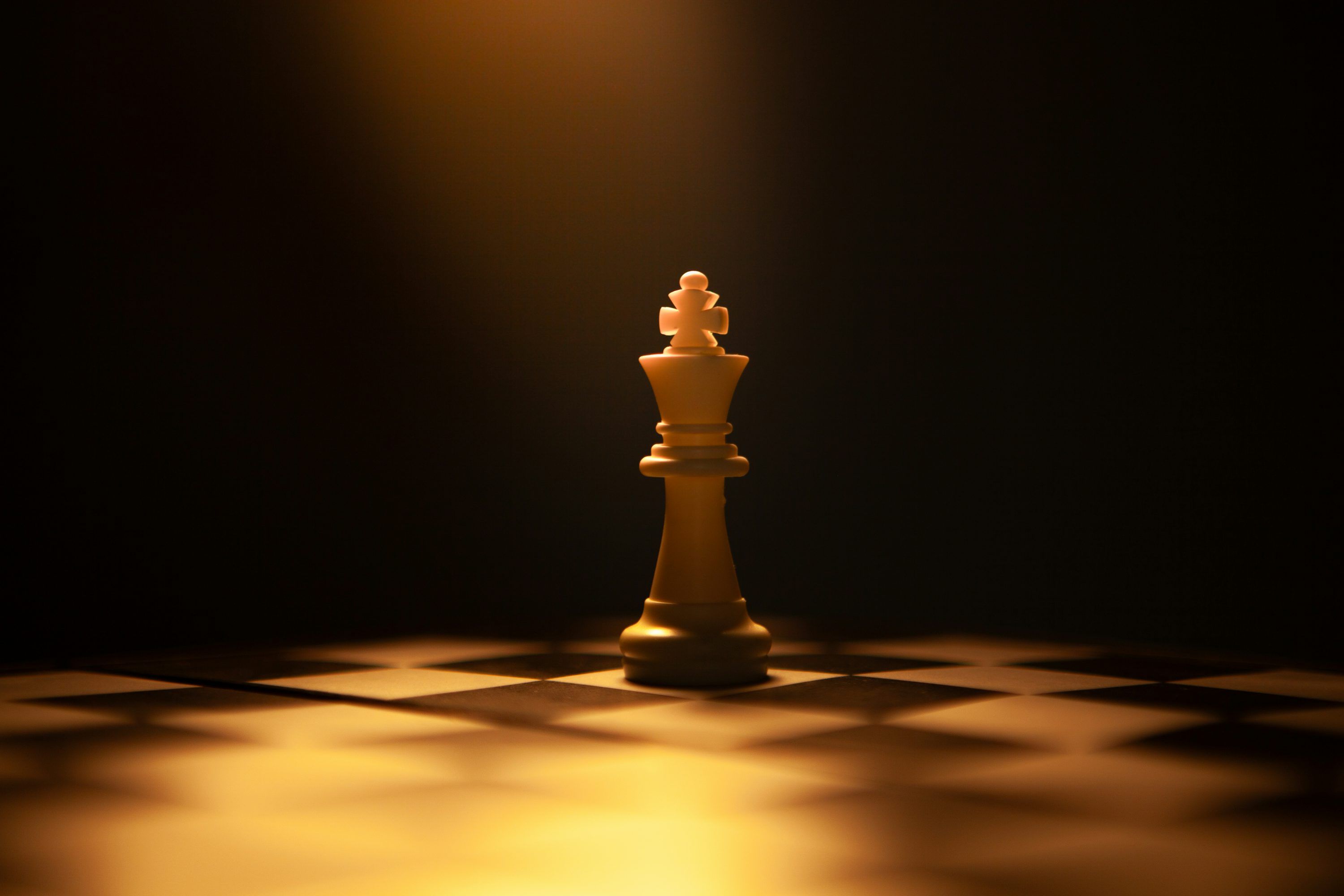 3000x2000 A single white chess king on a dark background