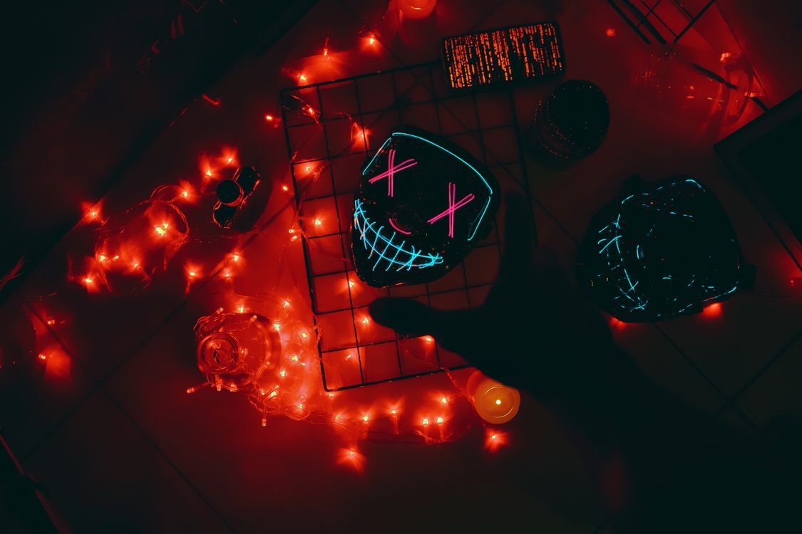 1125x750 Silhouette of Hand over Neon Mask on Table · Free