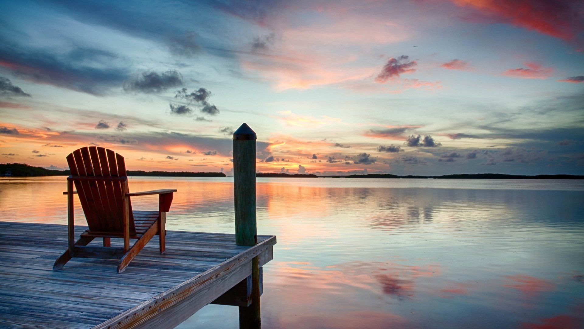 1920x1080 Sunset Serenity: Lakeside Chair HD Wallpaperx1080