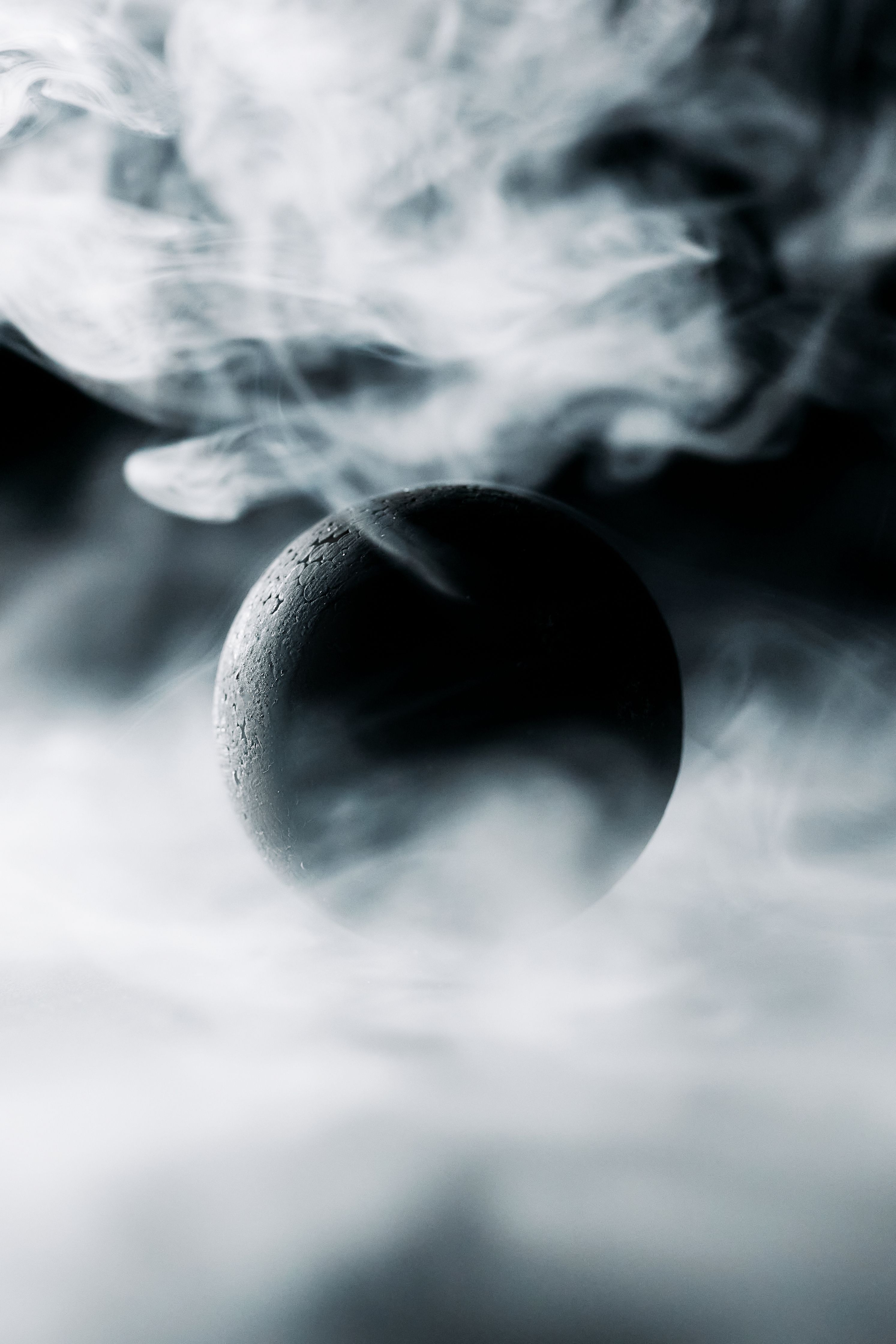 2987x4480 A Black Ball Surrounded by Smoke · Free