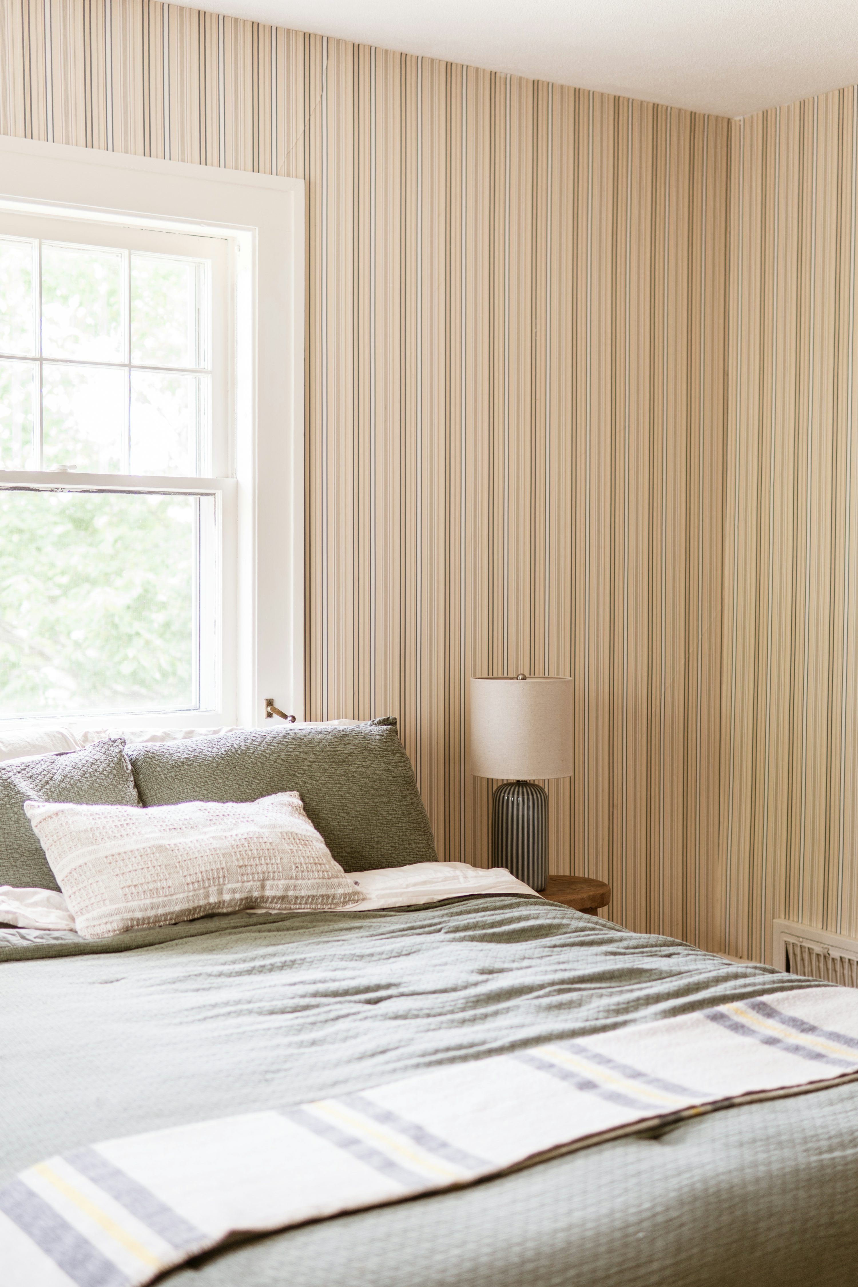 3000x4500 Cozy bedroom with green bedding, striped wallpaper, and a window