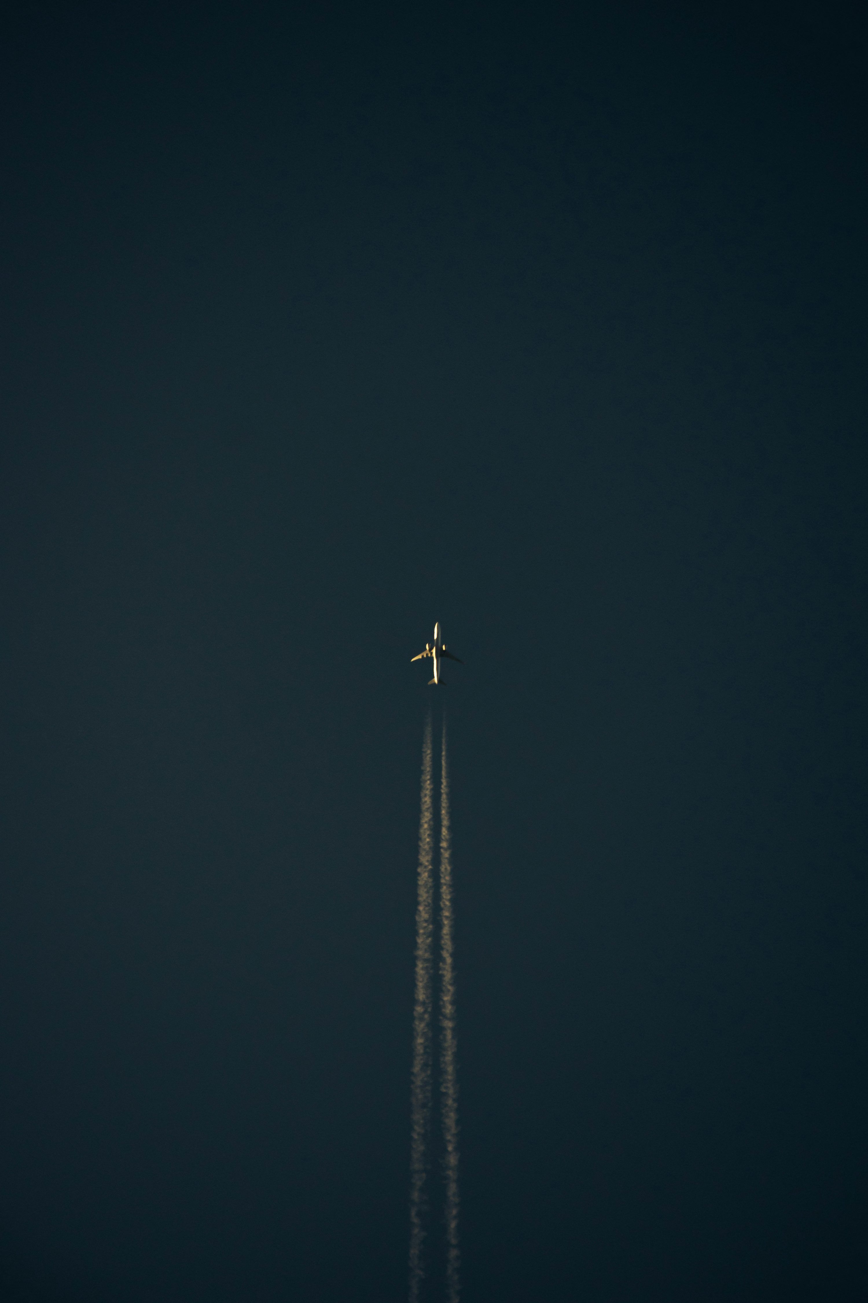 3000x4501 An airplane is flying in the dark sky