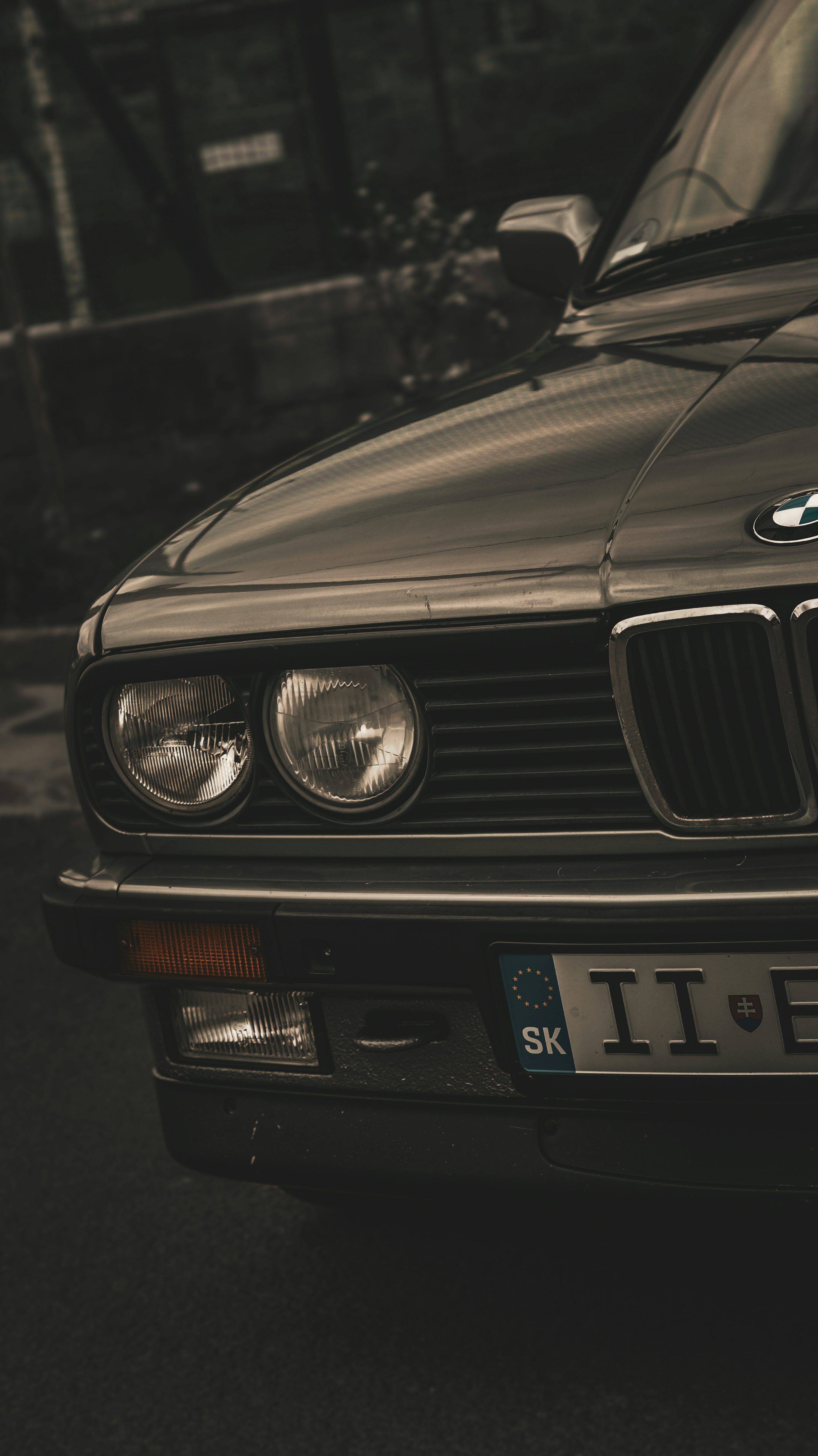 3000x5341 A black bmw is parked on the side of the road