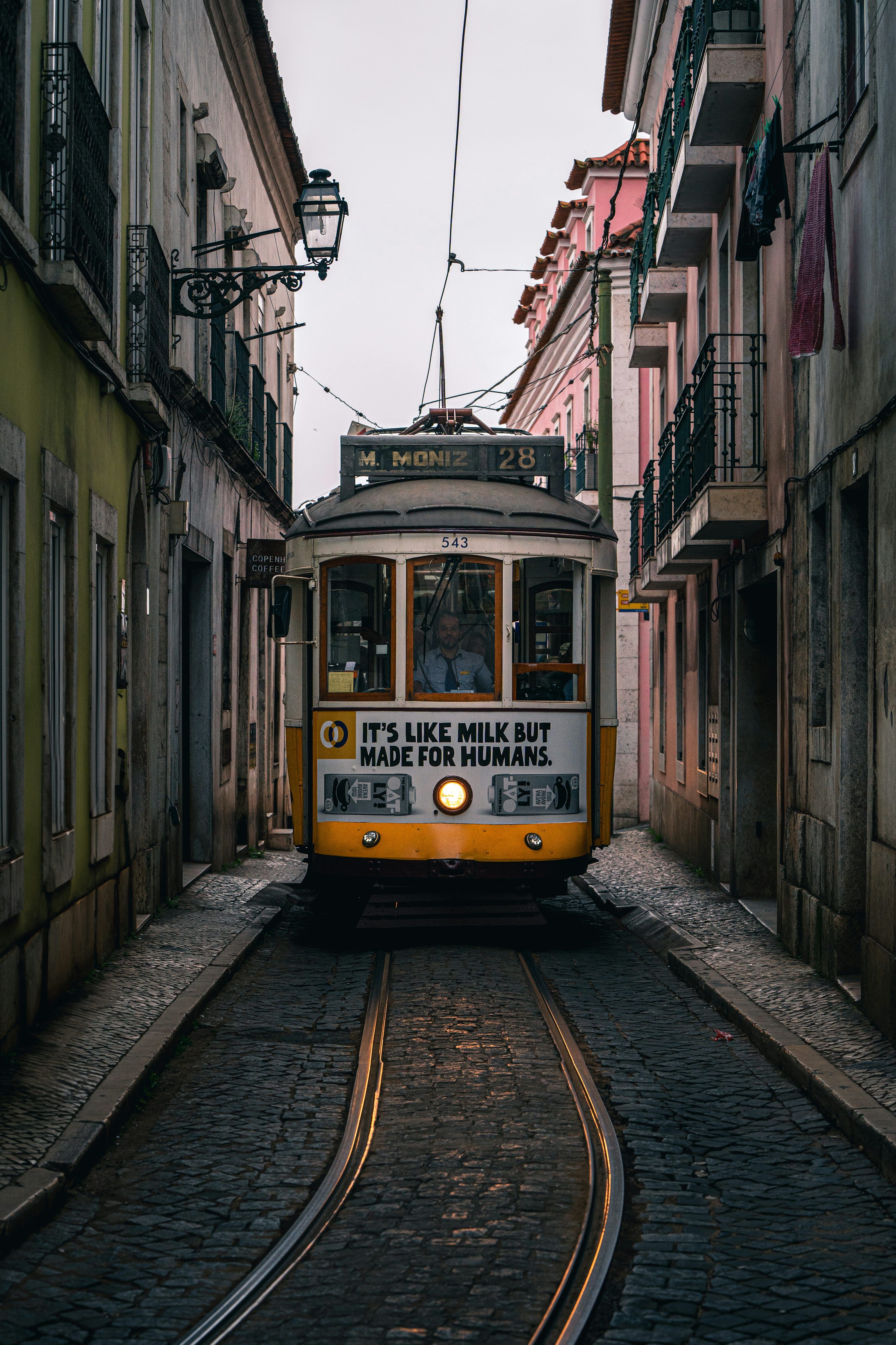 3000x4500 A vintage tram travels down a narrow european street