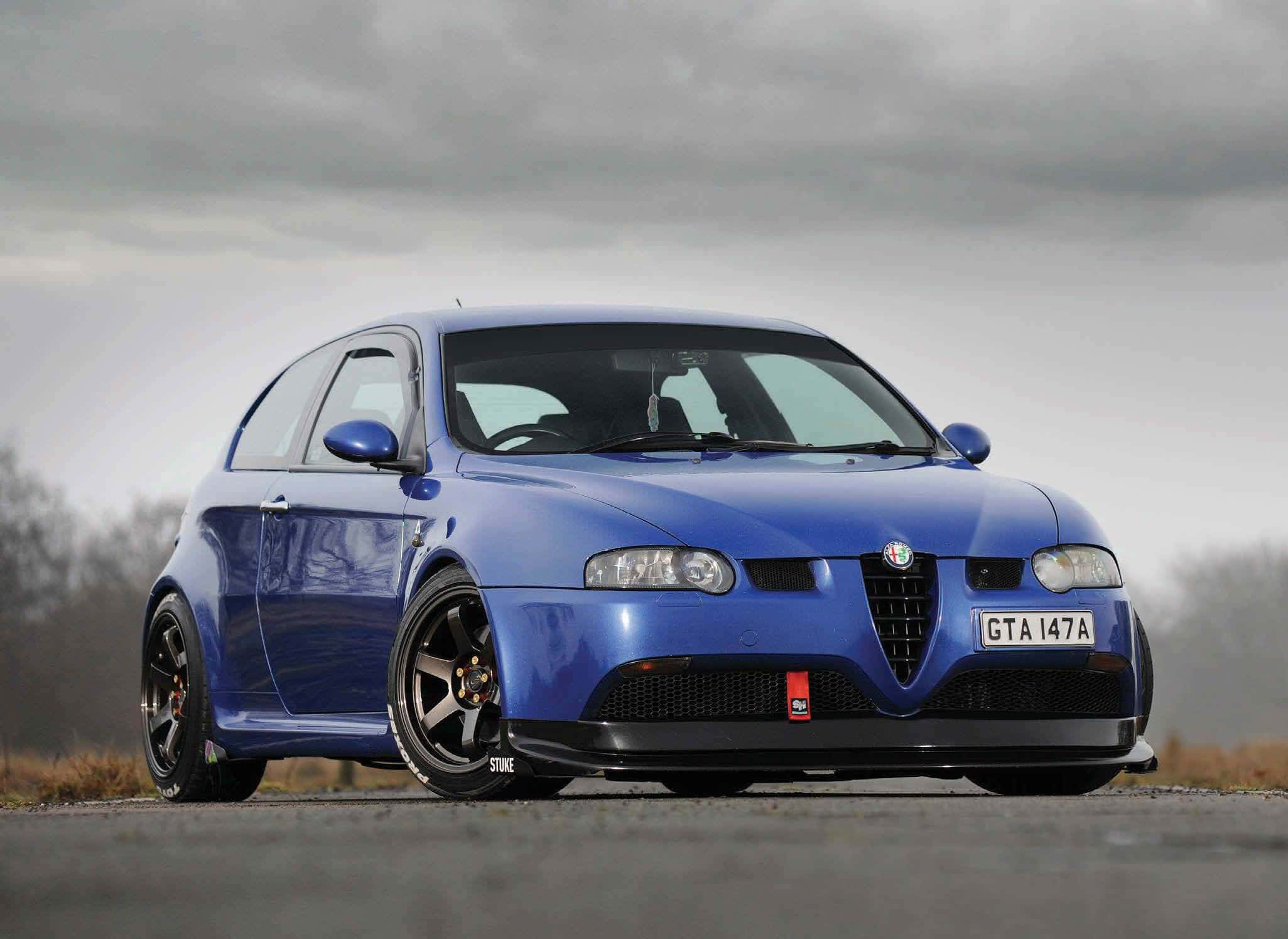 2051x1496 Download Caption: Sleek Alfa Romeo GT on a Scenic Drive Wallpaper