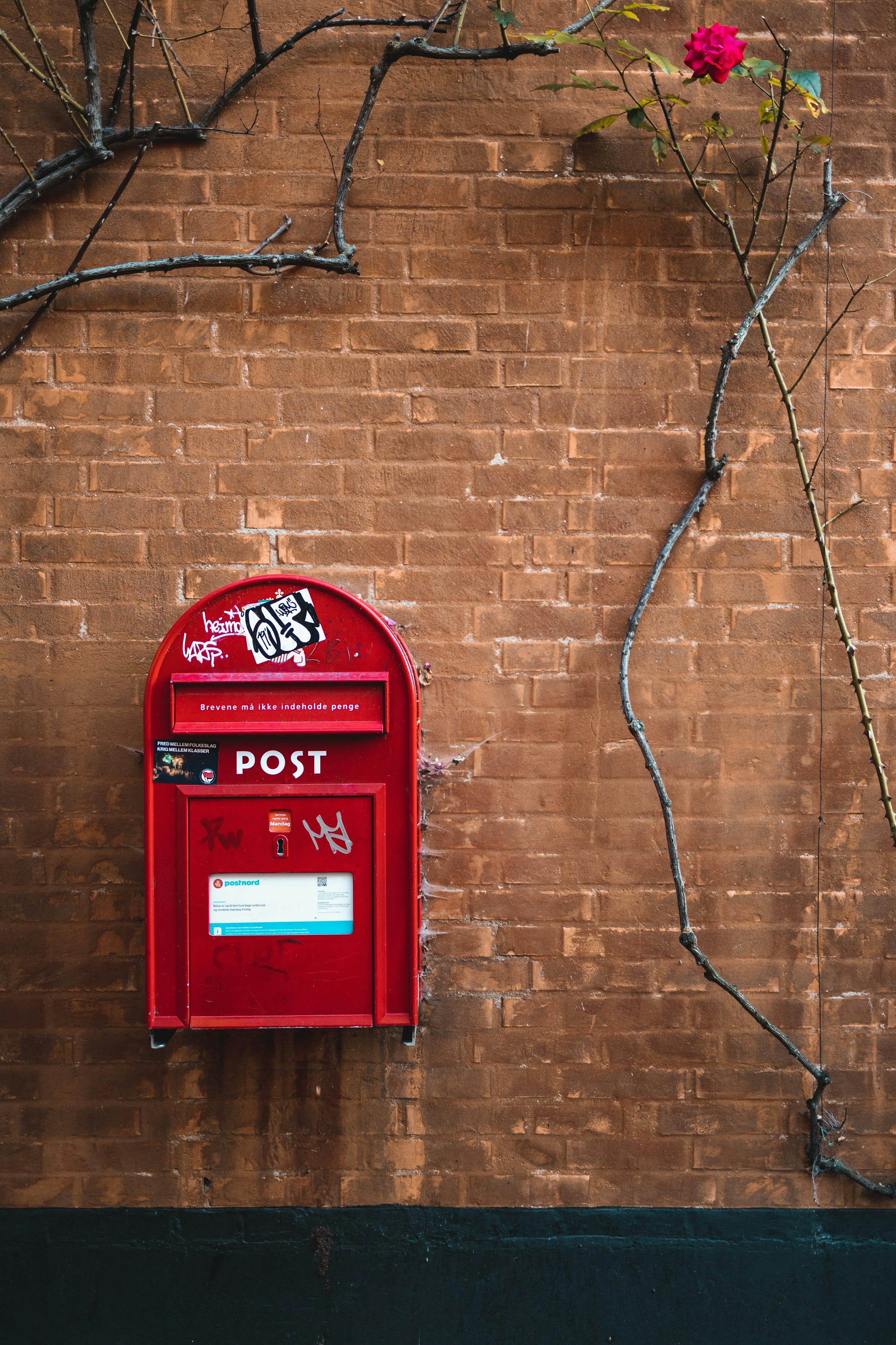 3000x4500 Red mail box mounted on brown brick wall