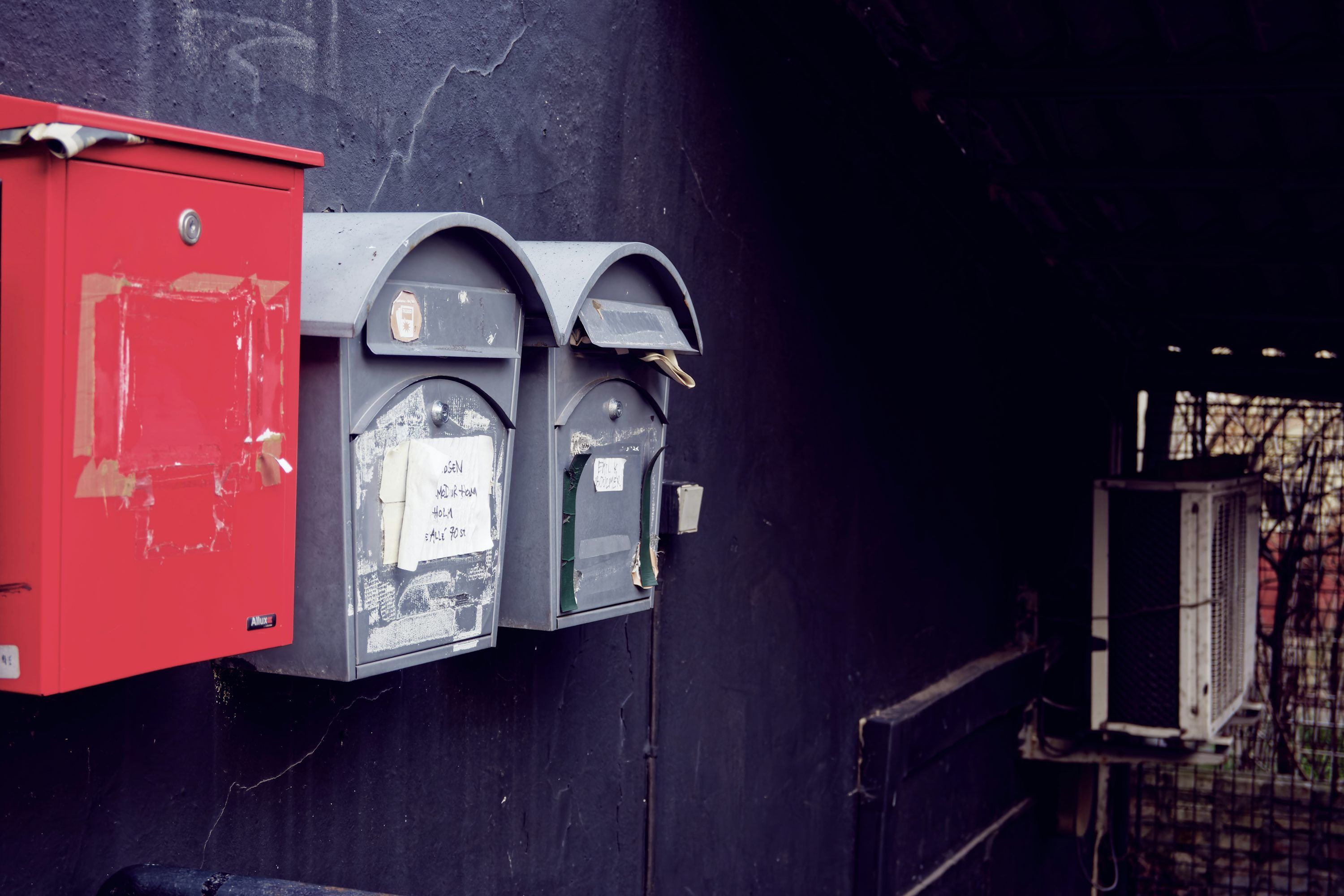 3000x2000 A row of mail boxes on the side of a building