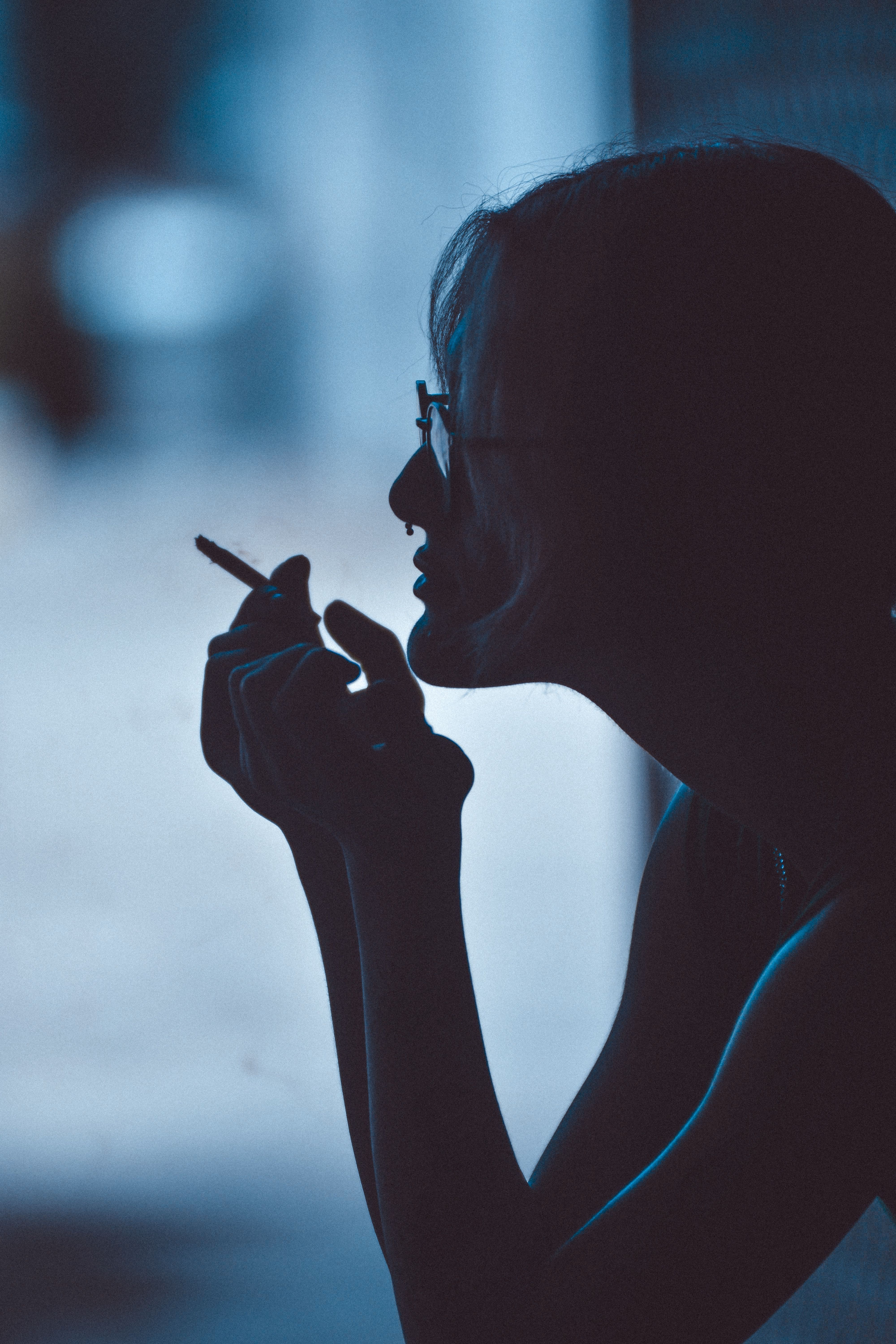 4000x6000 A woman smoking a cigarette in silhouette · Free