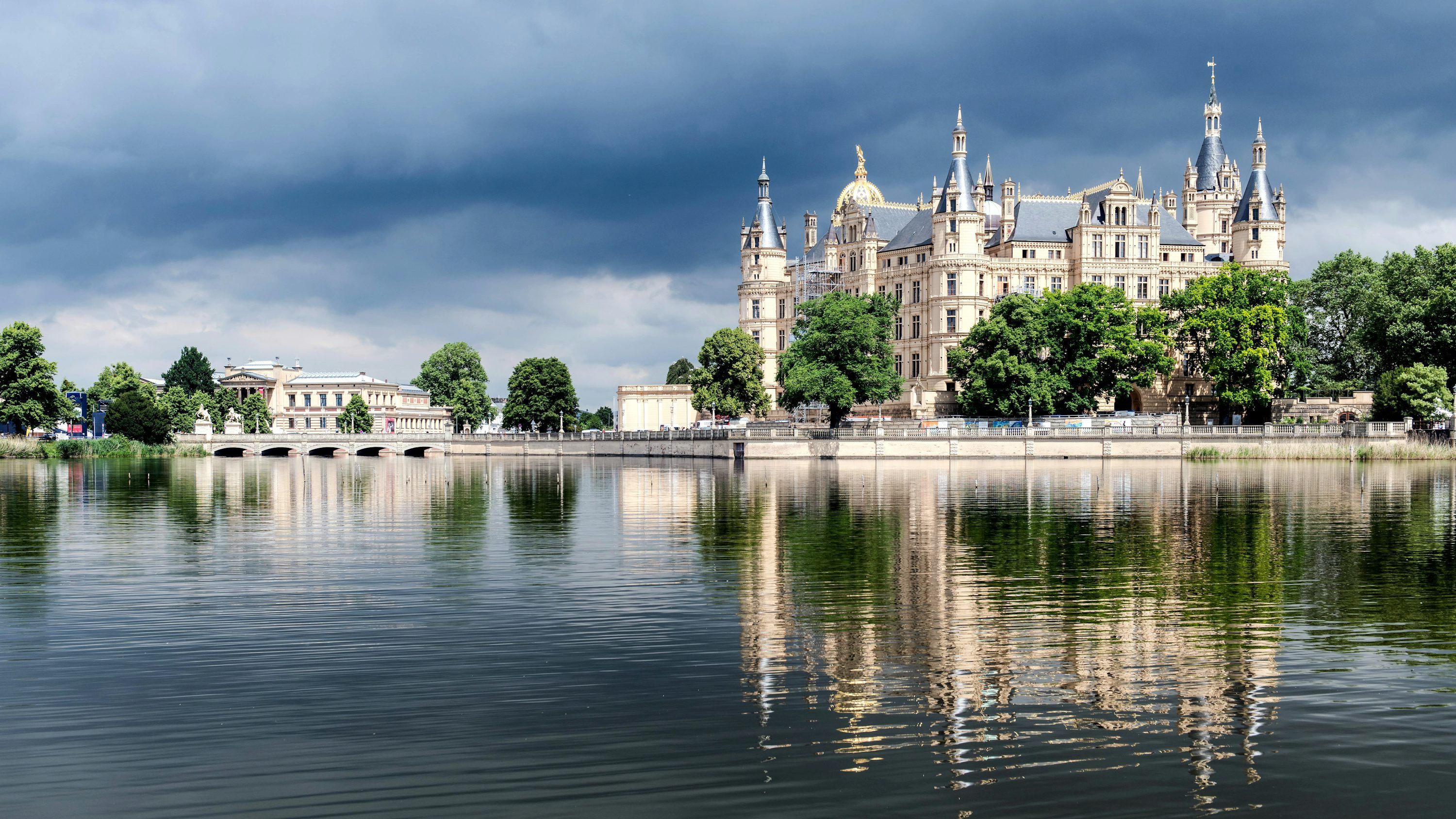 3000x1688 A castle on a hill by a body of water with Schwerin Palace in the background
