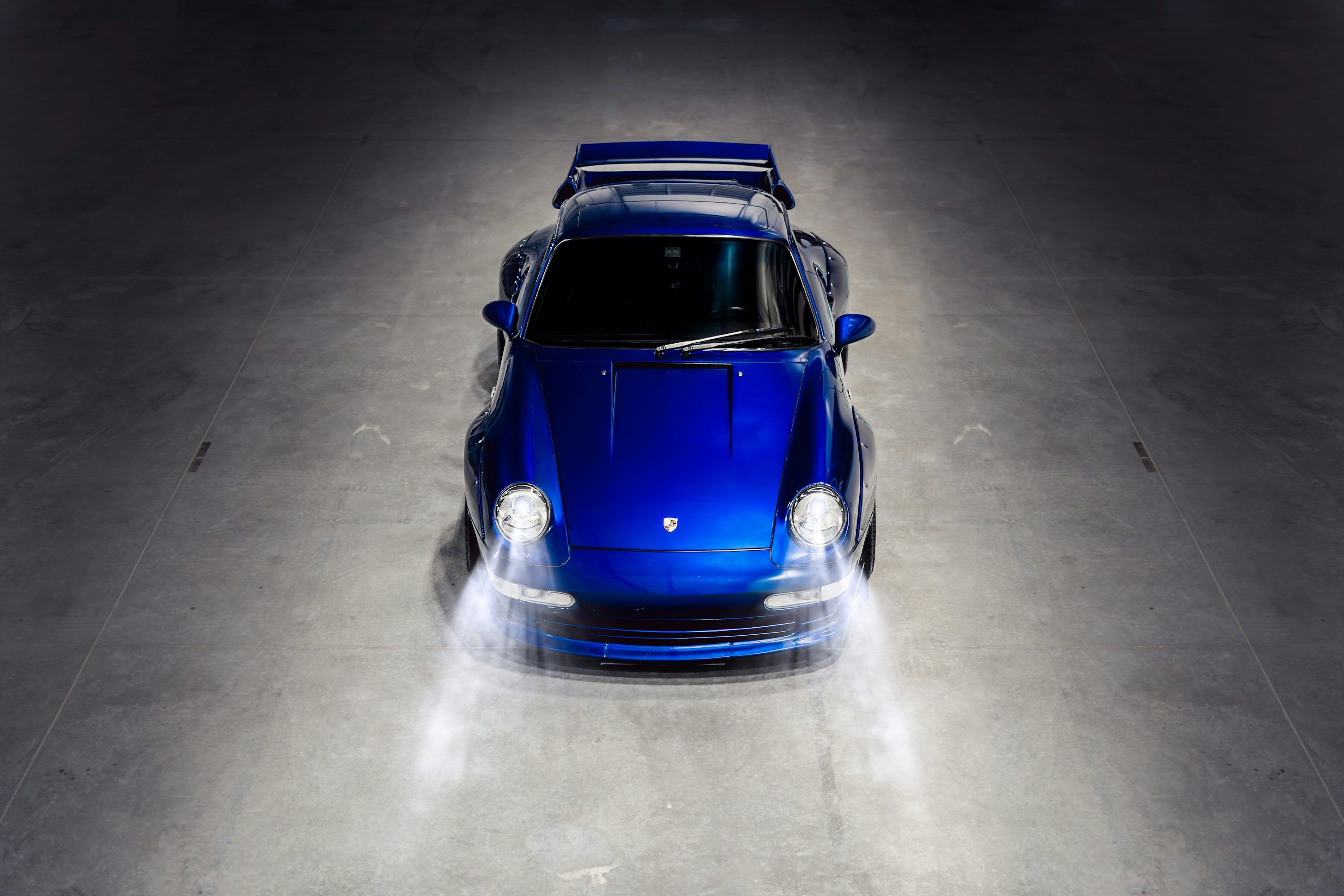 3000x2000 A blue car is parked in a dark room